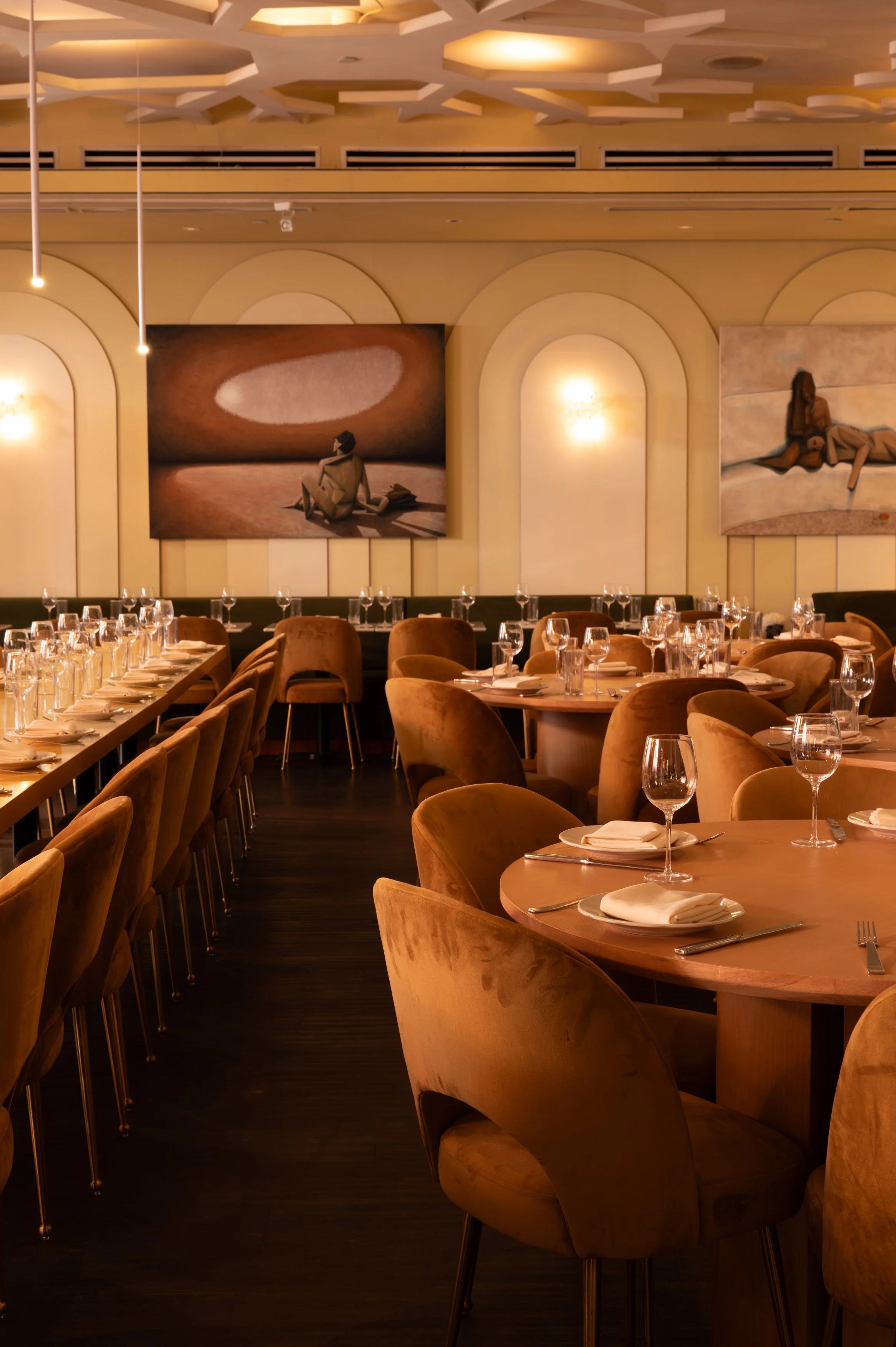 Candlelit tables and warm upholstered seating inside The Snow Lodge dining room