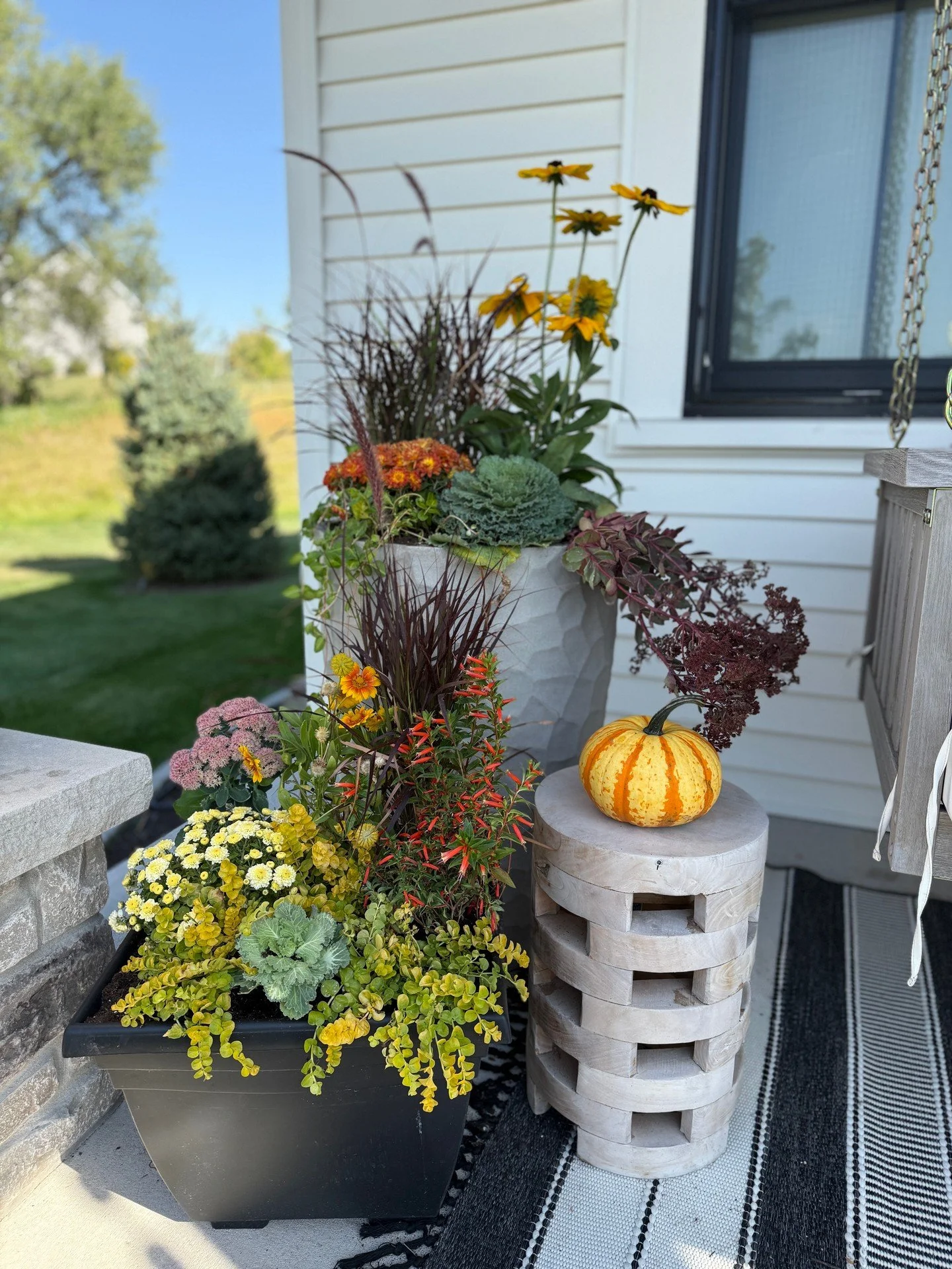 It may be 80 degrees out, but it’s still fall. This gorgeous porch is proof. Our client loves to decorate and brought us in to add some fresh pots and pumpkins to her already gorgeous porch decor. Love the mini pumpkin cascade all all the color
