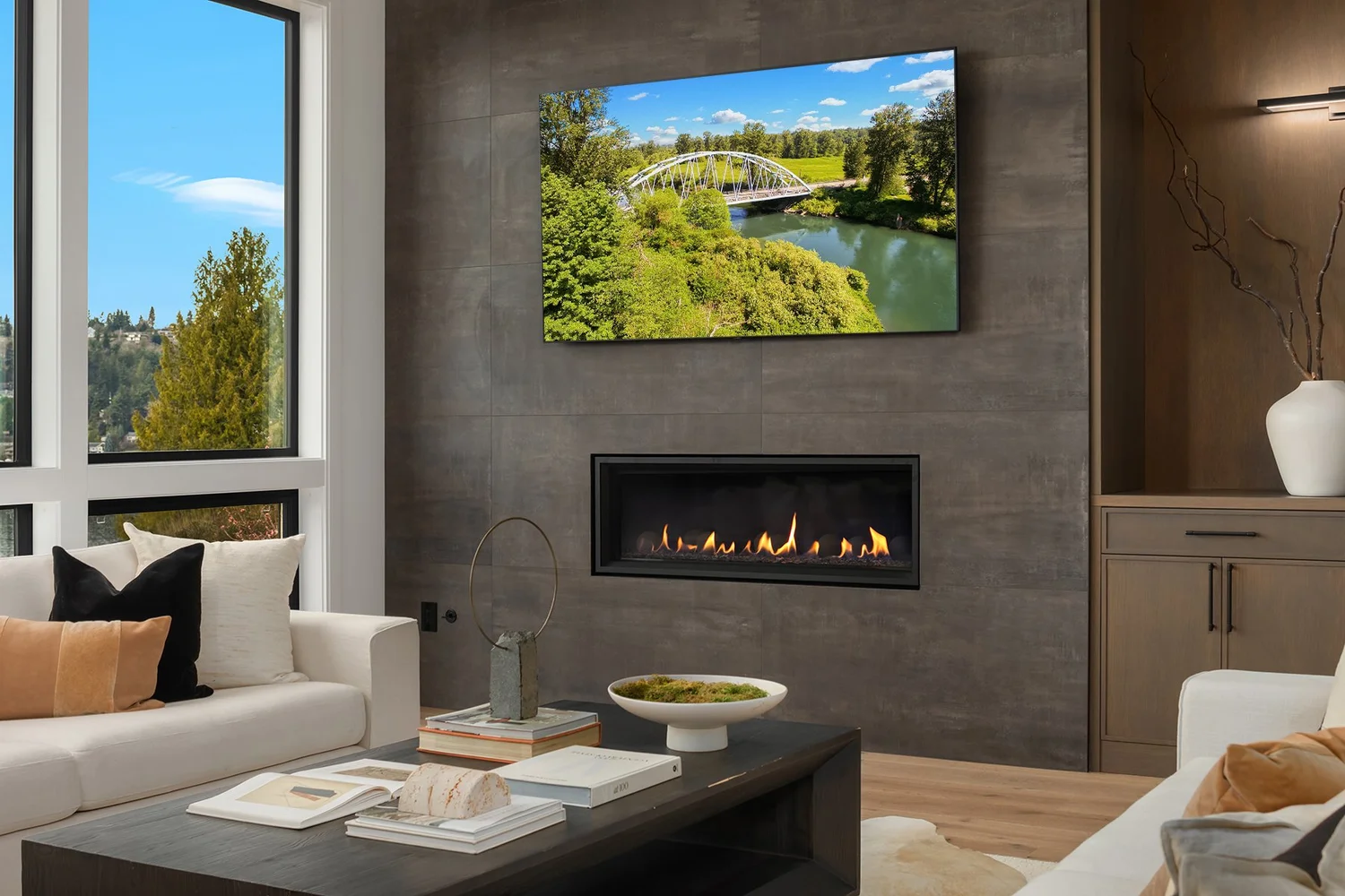 Living room with a fireplace, large windows, and neutral seating