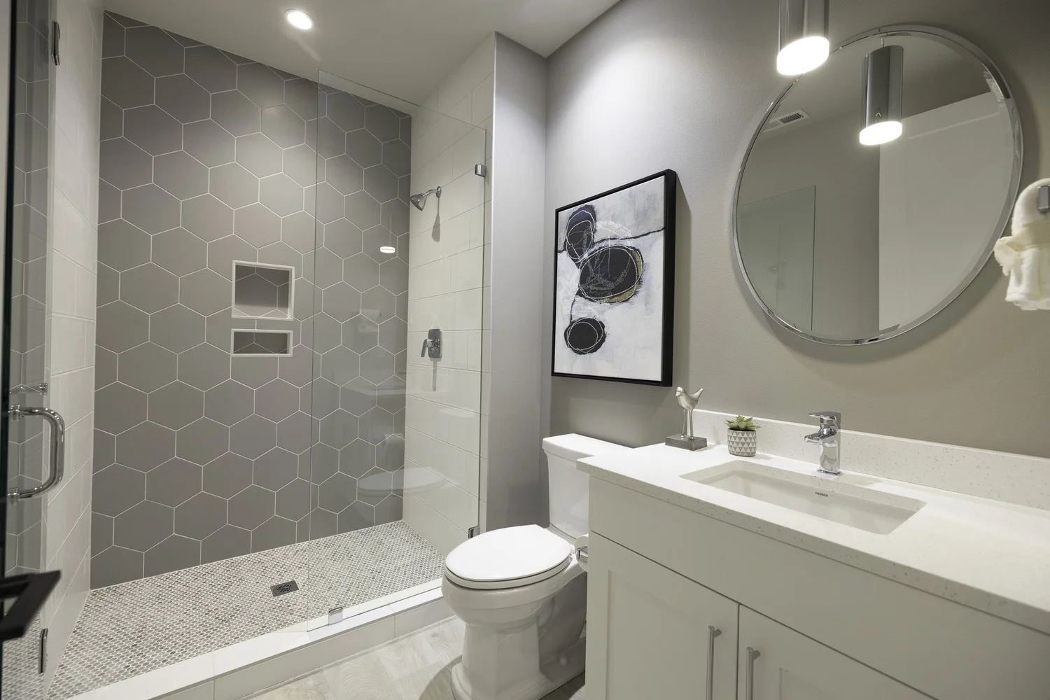 Bathroom with a white vanity and patterned shower tile