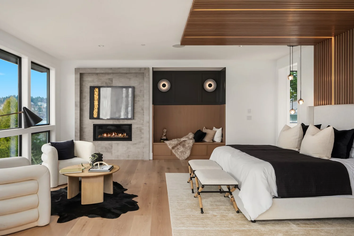 Bedroom with warm wood flooring, a fireplace, and upholstered seating