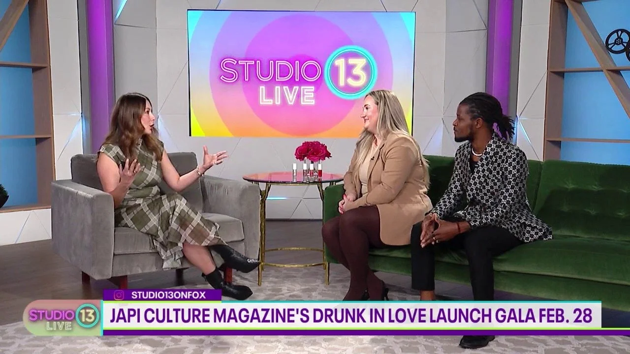 Three women sitting on couches having a conversation on a TV talk show set with a large screen behind them displaying 'STUDIO 13 LIVE.'