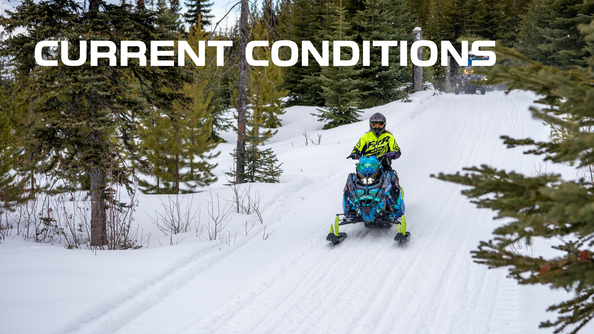 A snowboarder riding a snowmobile through a snowy forest trail, wearing a neon yellow-green jacket and black helmet, with trees and a person in the background. The text 'CURRENT CONDITIONS' overlays the image.