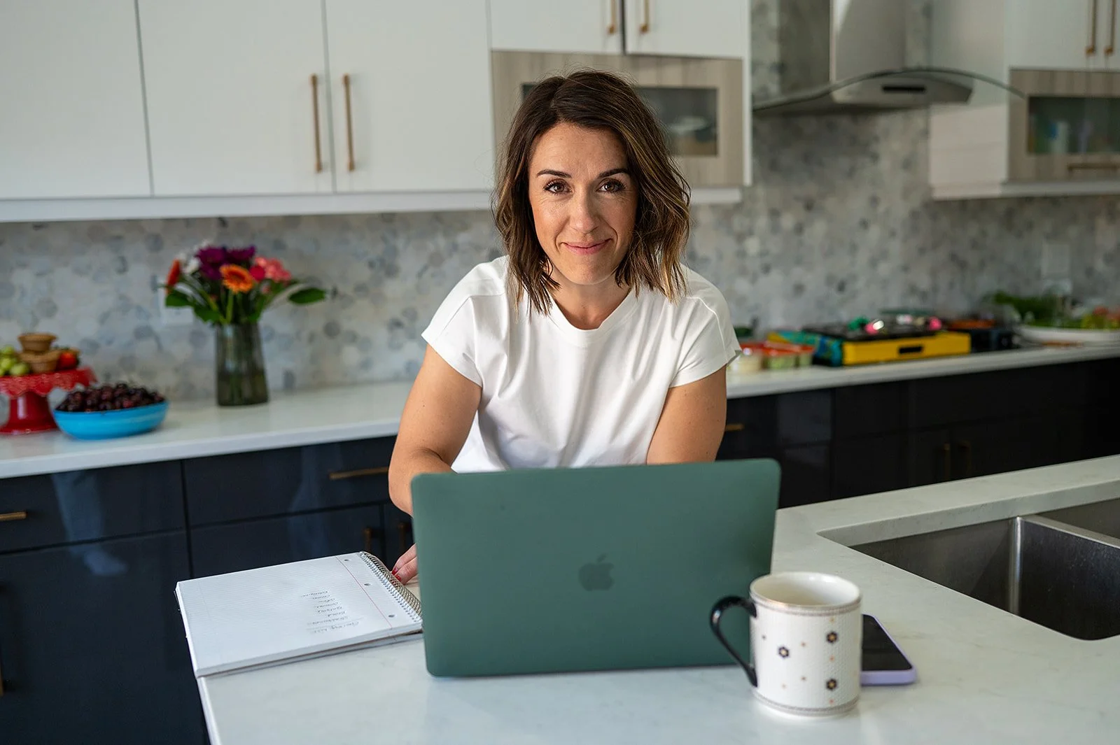 Registered dietitian smiles at her laptop camera while connecting with a client virtually.