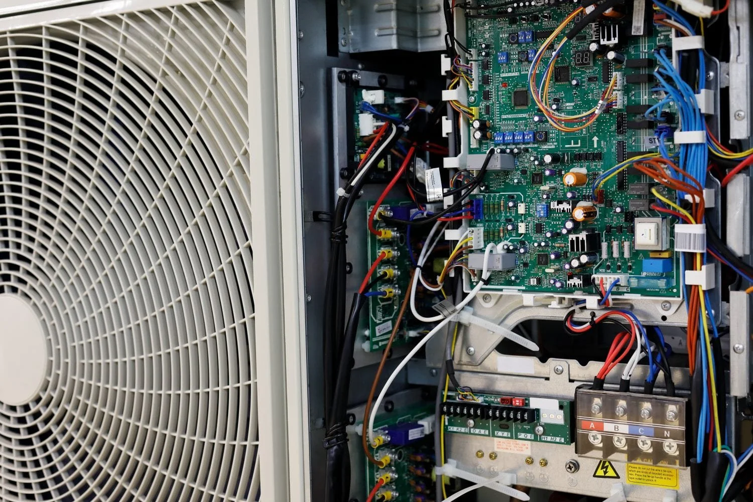 Interior view of an air conditioning unit with exposed electronic components, circuits, and wiring.