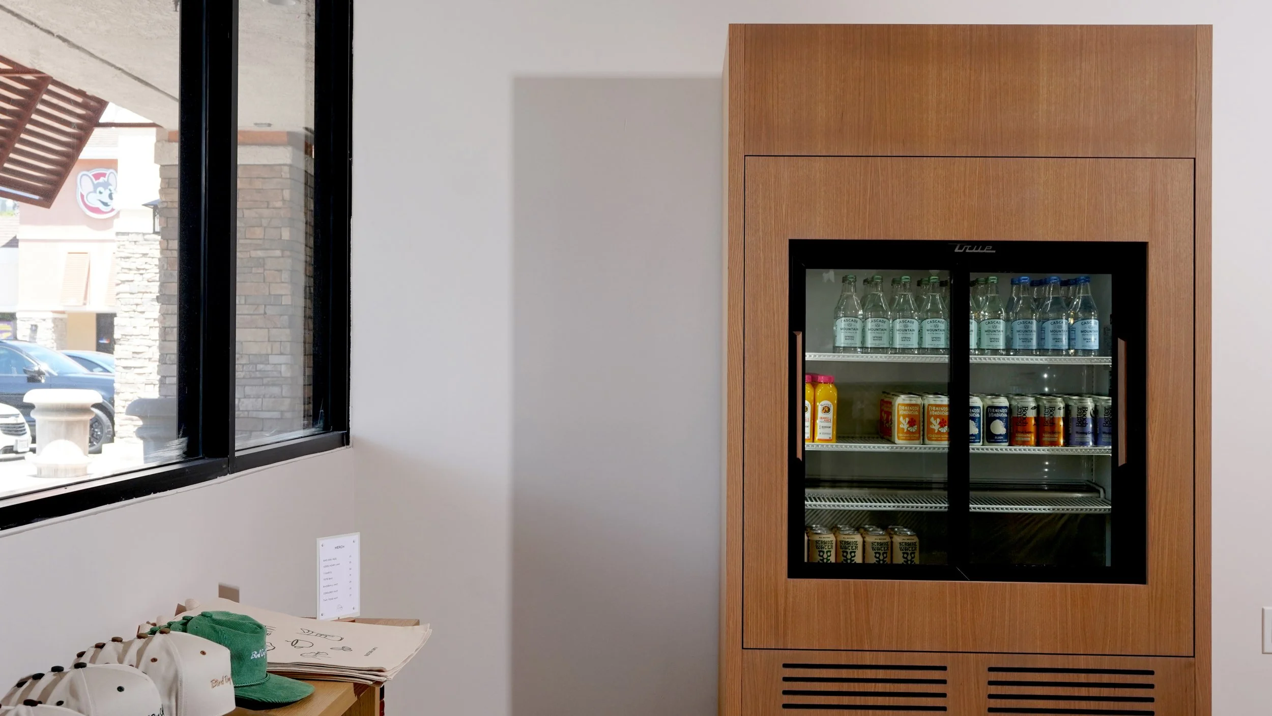Built-in beverage refrigerator with wood surround and modern commercial finishes for Bird Dog Coffee in Laguna Hills, Orange County.