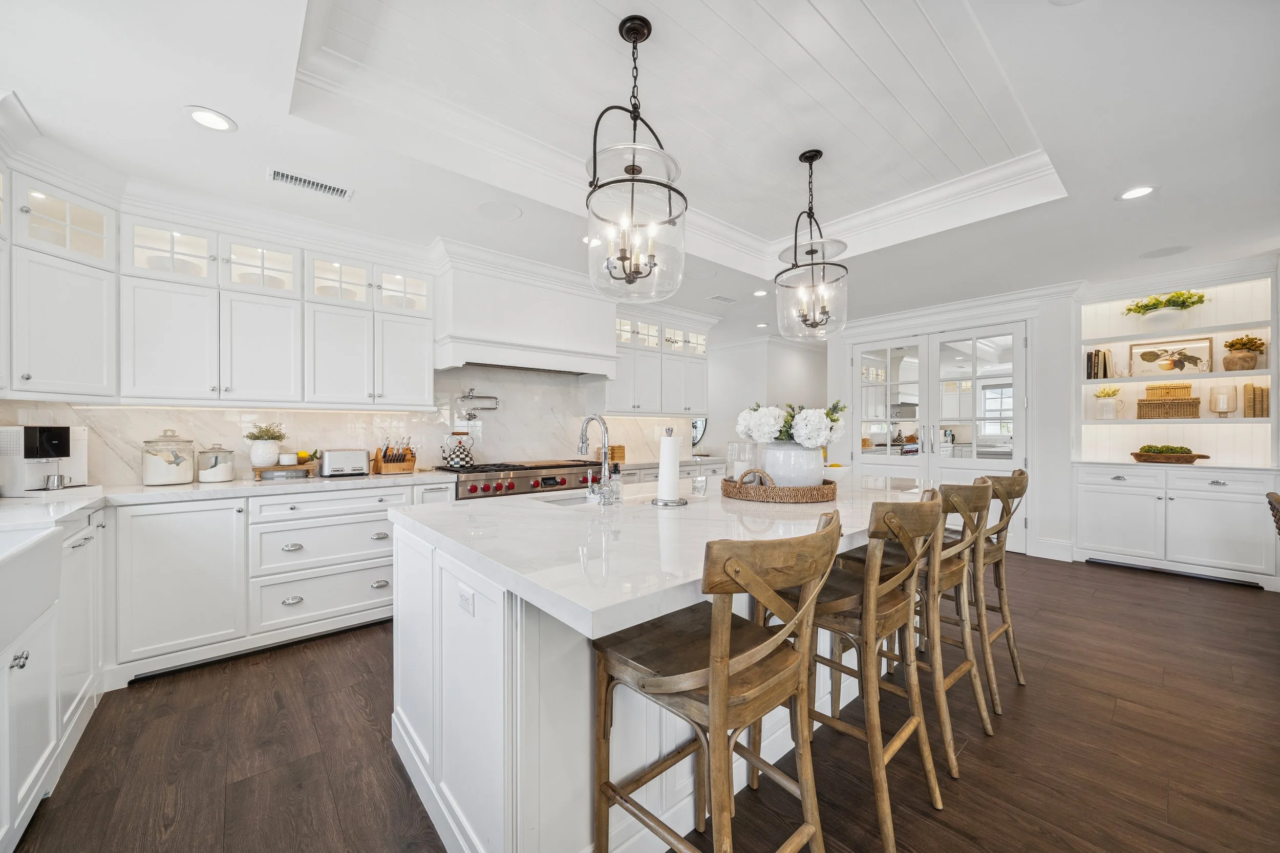 Spacious Orange County kitchen remodel with a large entertaining island, custom white cabinetry, built-in storage, and multiple seating areas.