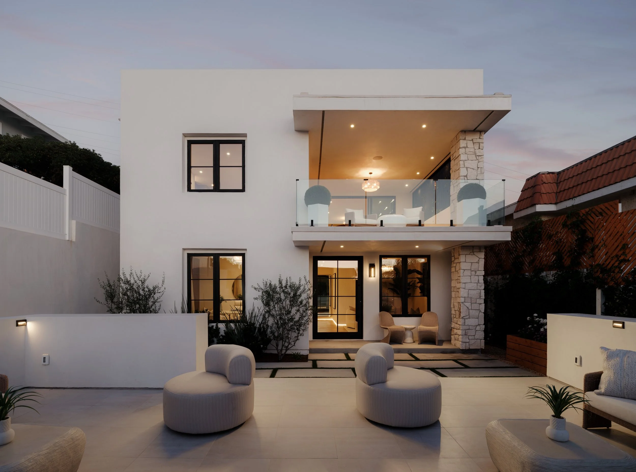 A refined white brick home exterior by an Orange County general contractor featuring modern black shutters in Orange County.