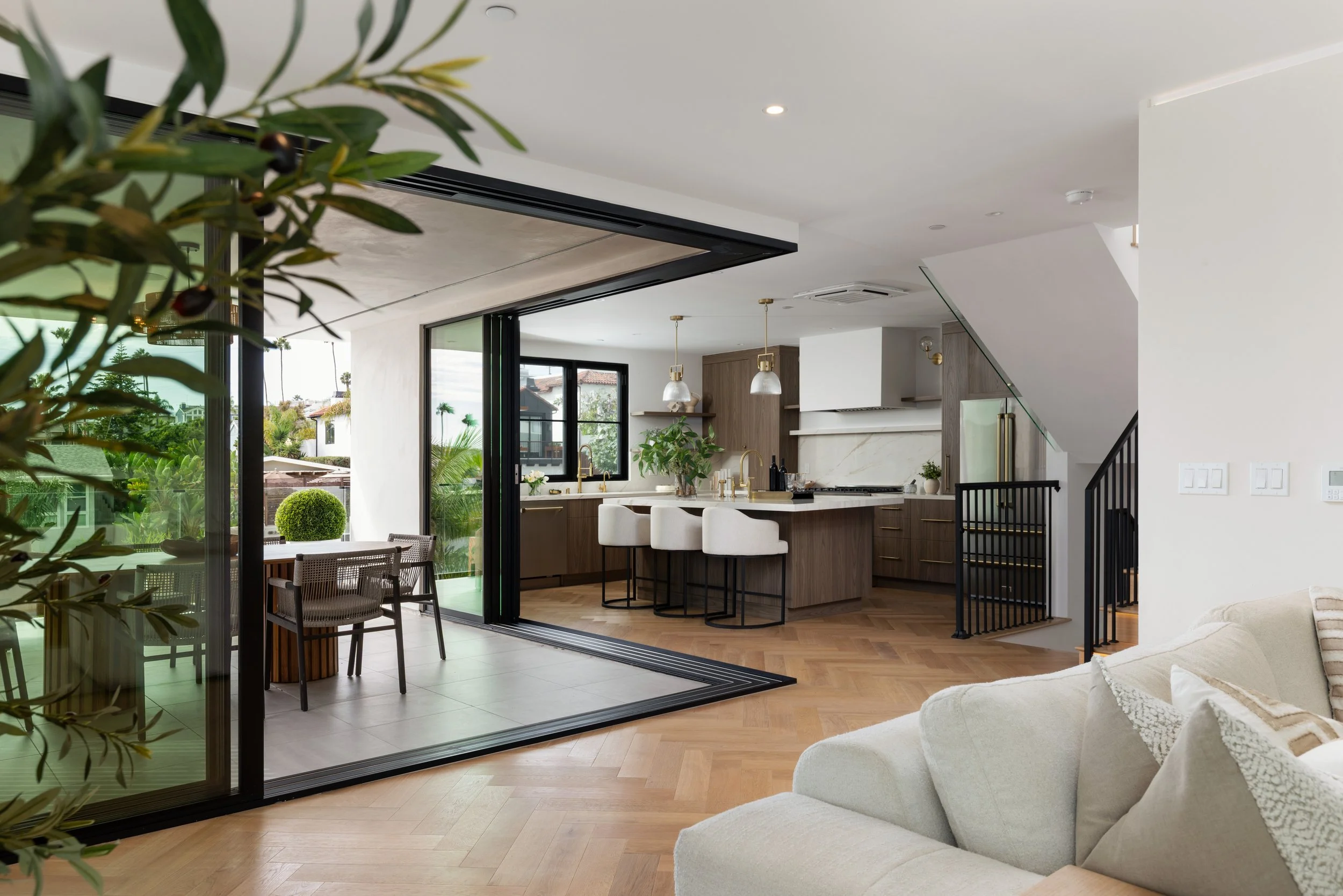 Orange County home remodel with an open kitchen, living room, and wide sliding glass doors creating a seamless connection to the covered patio.