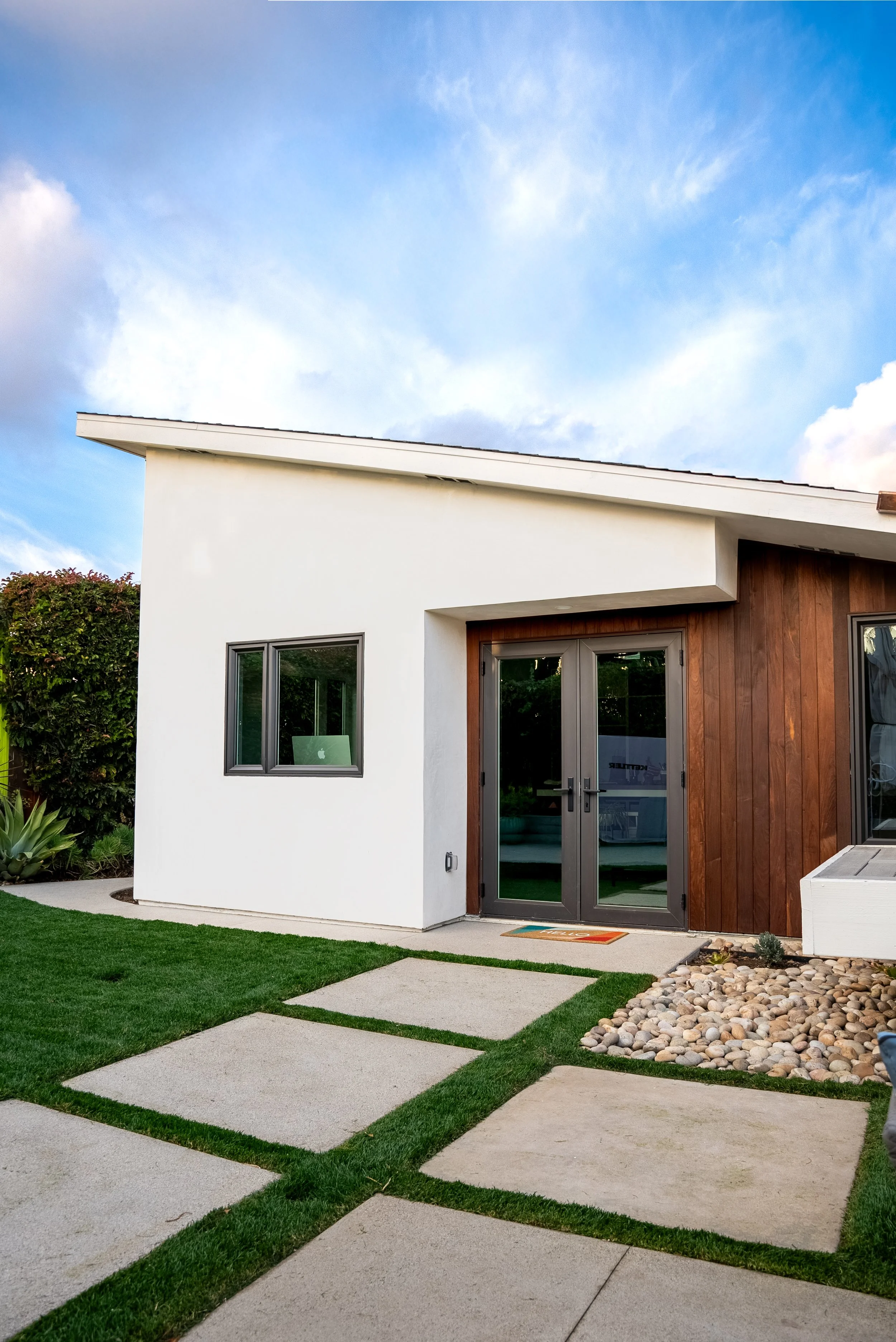 Angled exterior view of the finished ADU showcasing clean modern lines, sloped roof design, and seamless indoor-outdoor connection in an Orange County backyard.