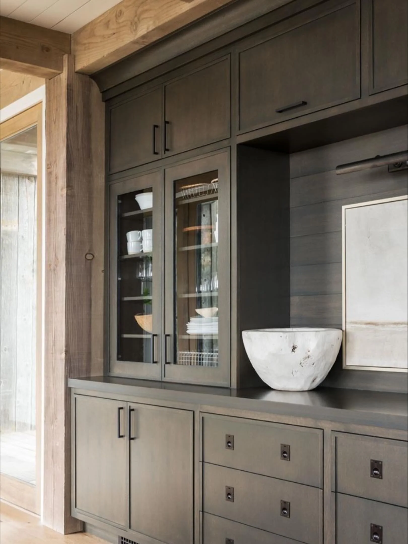 A modern yet timeless cabinetry moment!

Rich wood tones, clean lines, and subtle detailing bring depth and warmth into this space. 

The balance of open glass doors with closed storage makes it both functional and refined &mdash; a perfect example o