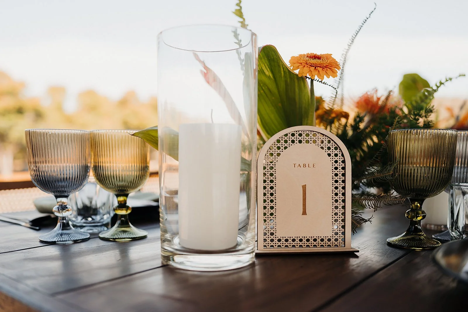 Table number with candles and orange gerbera at Tierra Tropical Polo Club, San Pancho