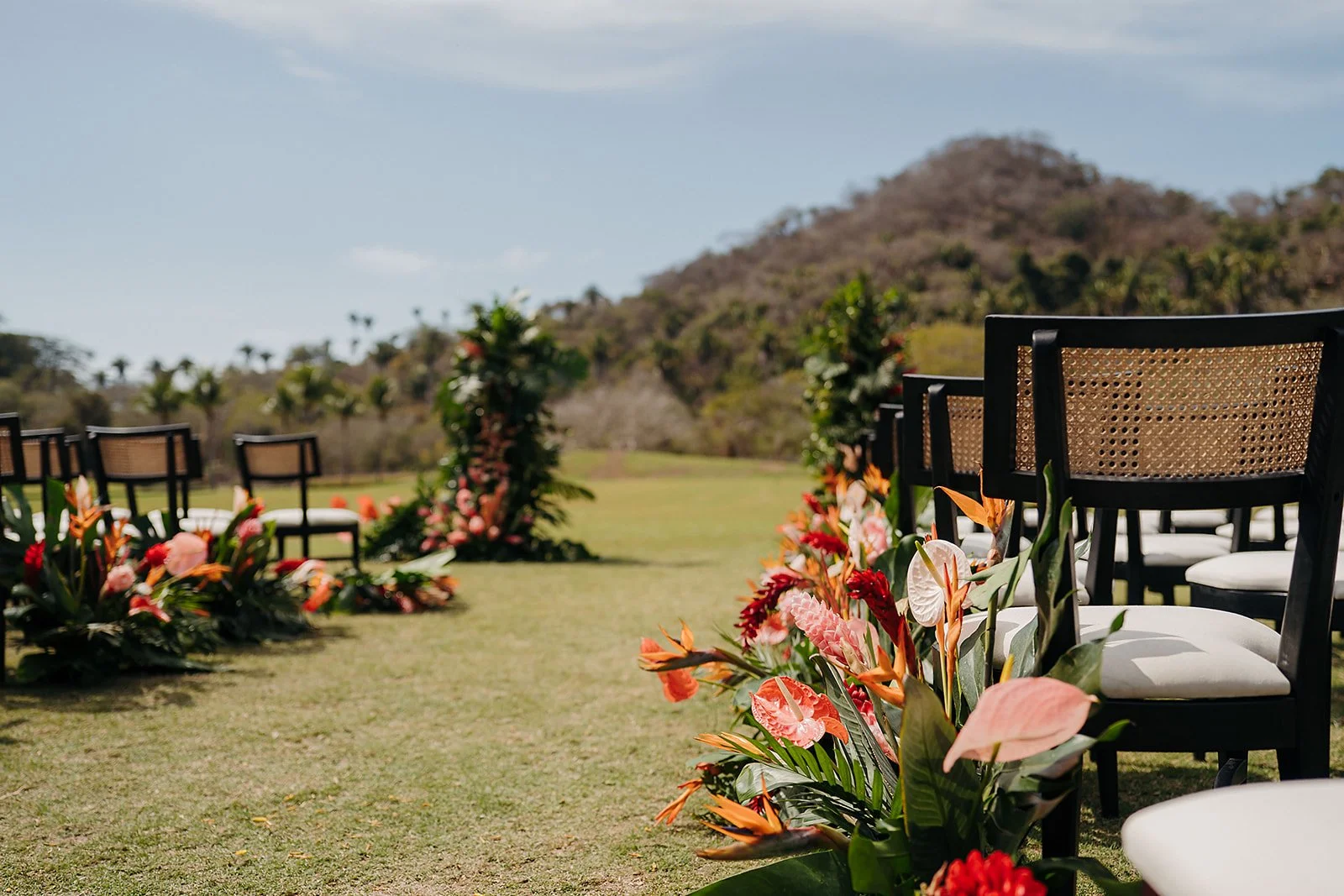 Detail of a grounded aisle installation in coral and orange at Tierra Tropical Polo Club
