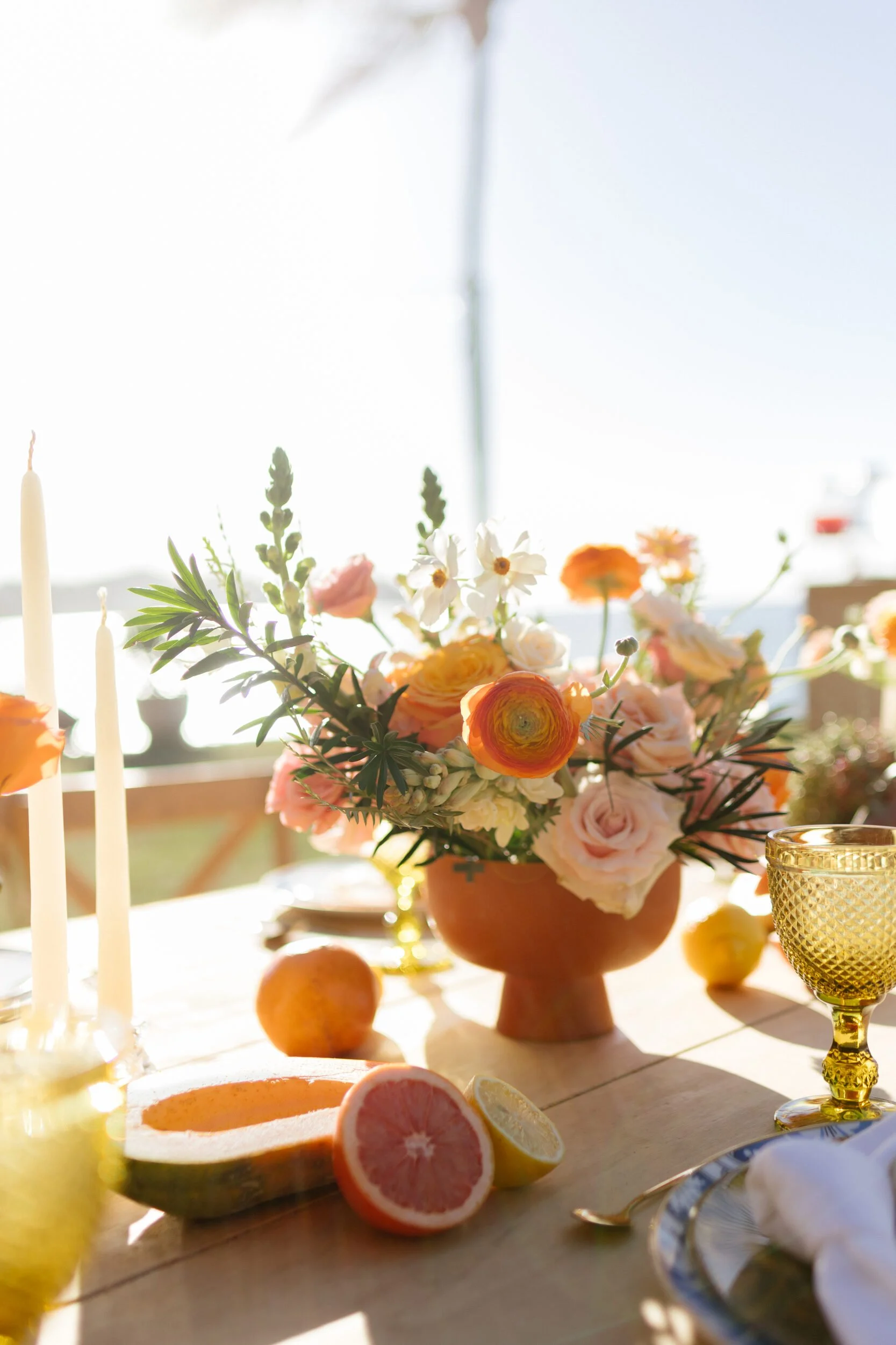 Centerpiece with grapefruit, peach roses and taper candles