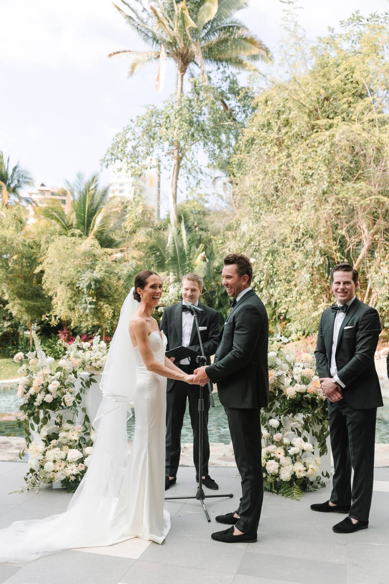 Couple exchanging vows between grounded white ceremony florals at Garza Blanca