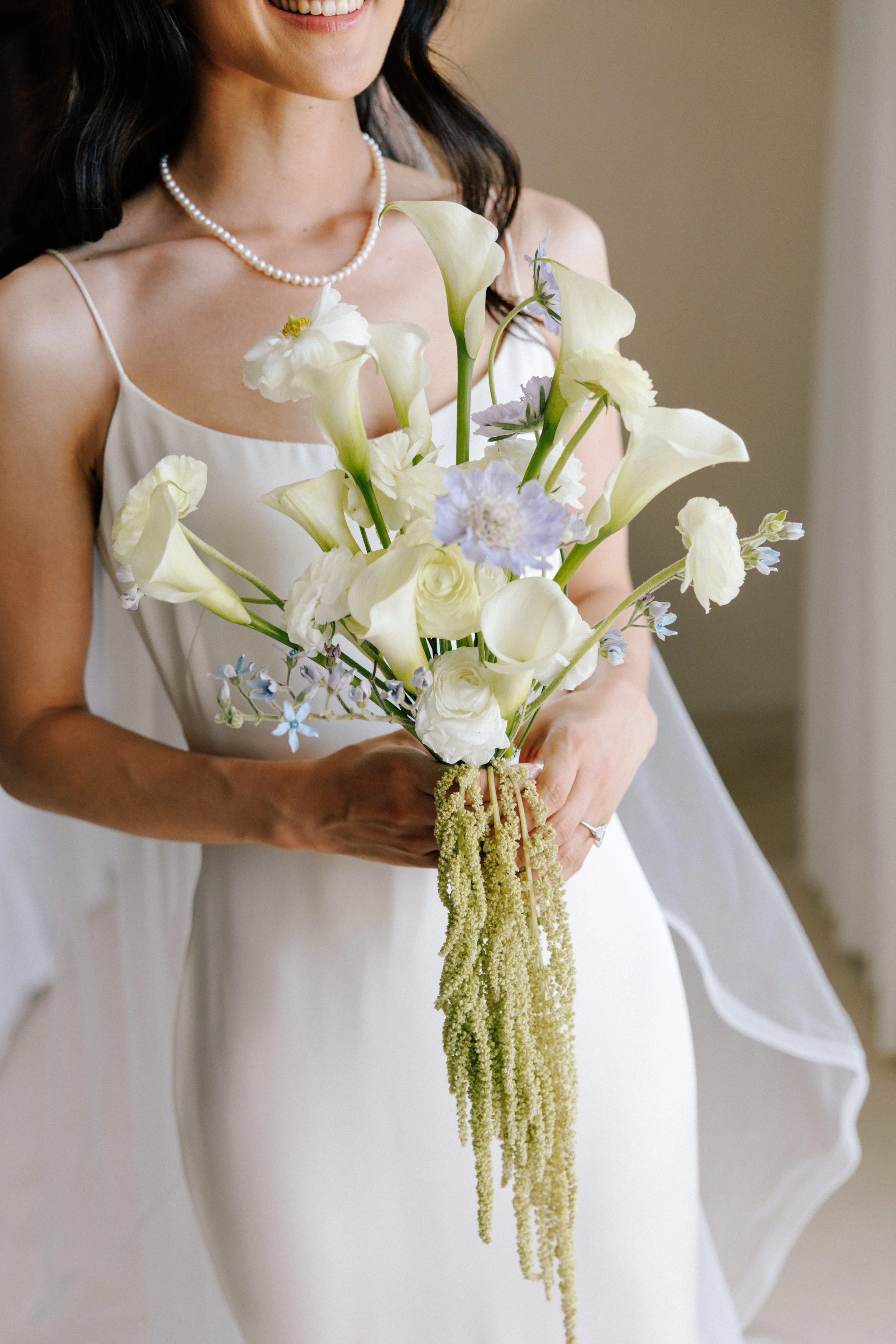 Bride holding her white bouquet in soft morning light before a Puerto Vallarta wedding