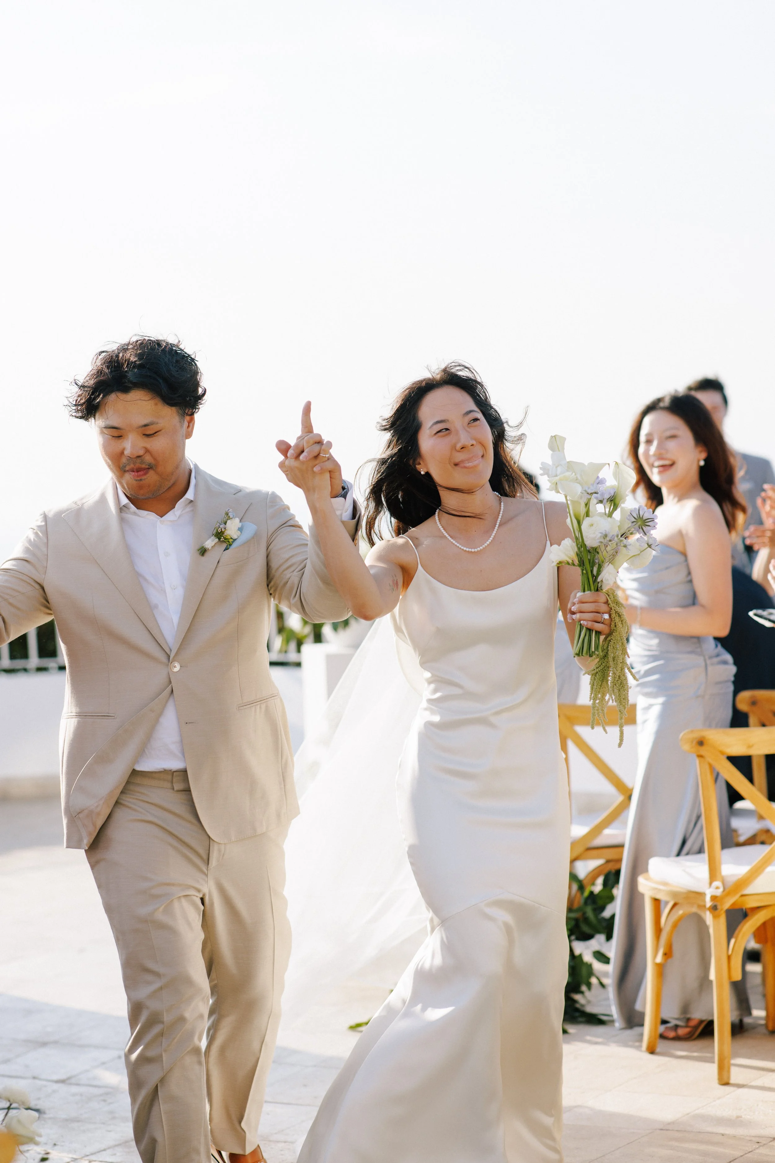  Newlyweds celebrating the recessional after their oceanfront ceremony 