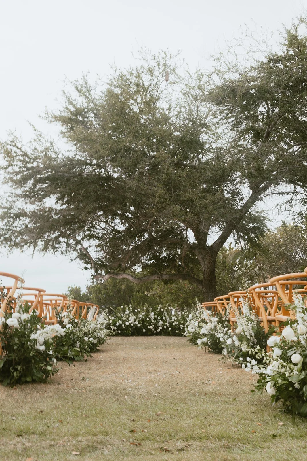 Wedding aisle lined with grounded white and green floral arrangements in Punta Mita