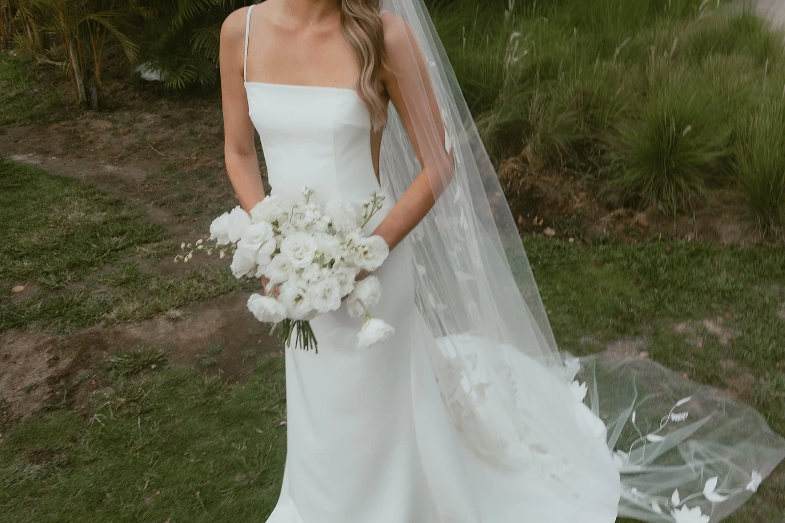 Bride holding a white bridal bouquet with her veil at a Punta Mita wedding