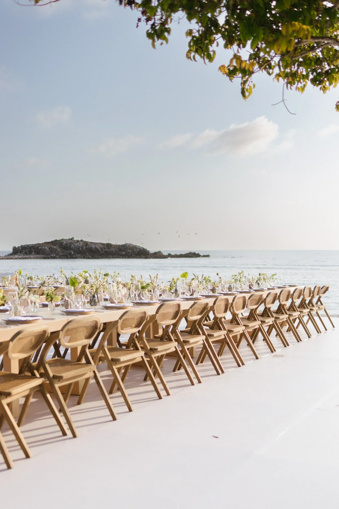 Long oceanfront reception table set under a tree at a Punta Mita wedding