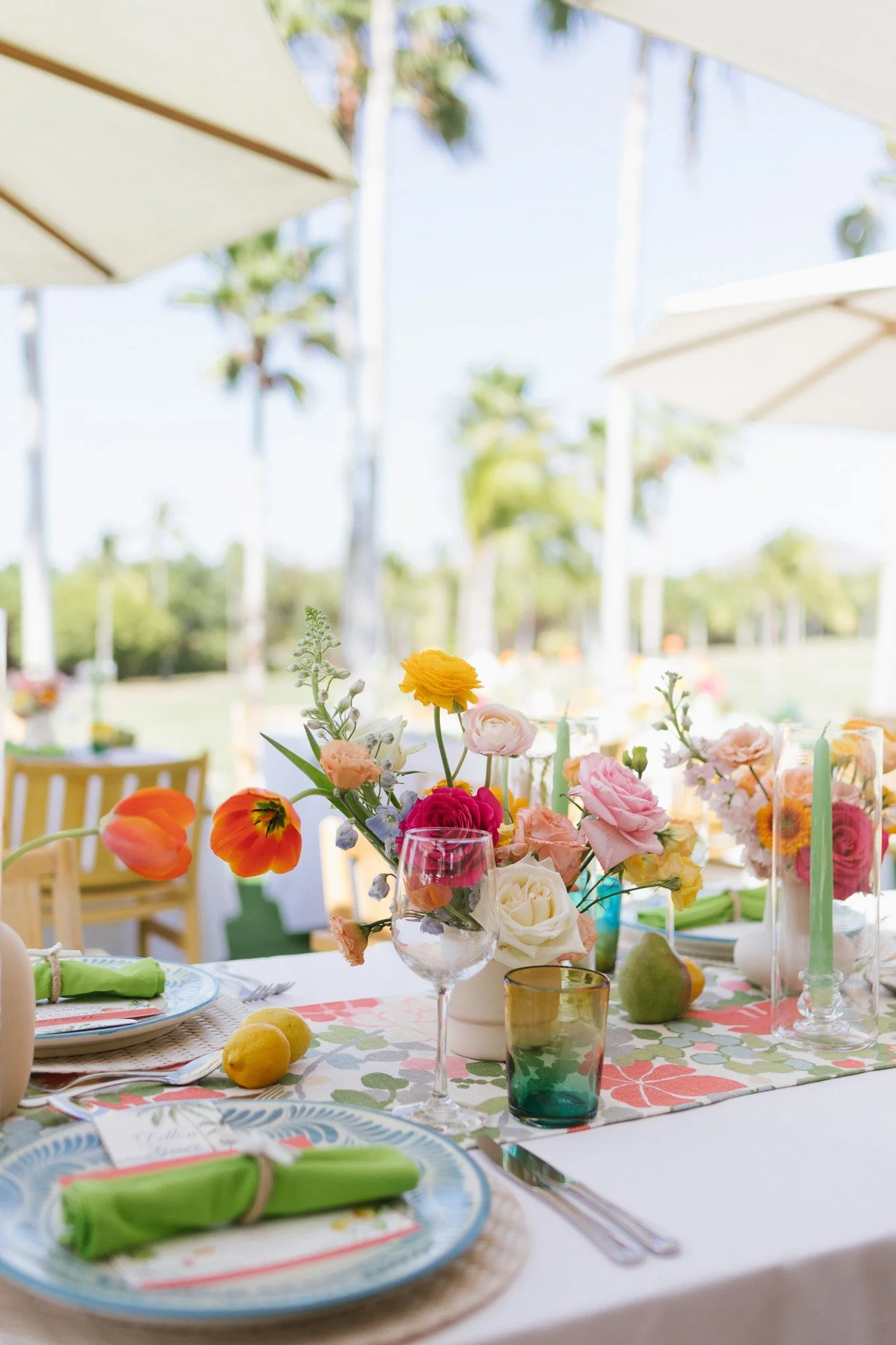 Welcome party table with a runner of coral, orange and yellow florals at Four Seasons Punta Mita