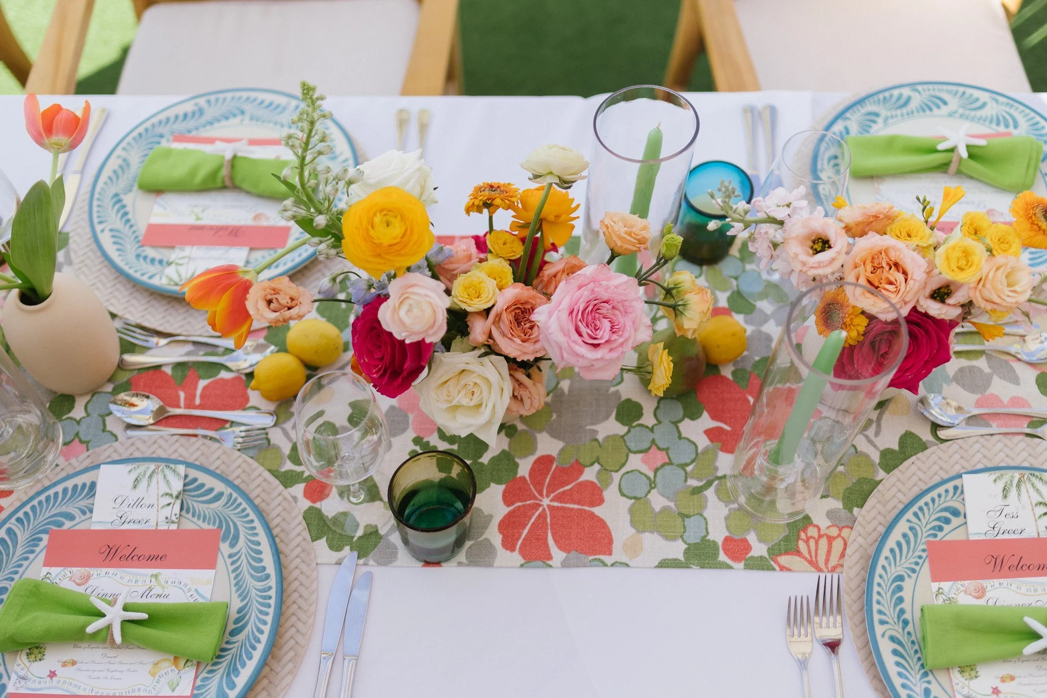 Citrus-toned centerpiece with ranunculus and poppies beside pears and lemons at Four Seasons Punta Mita