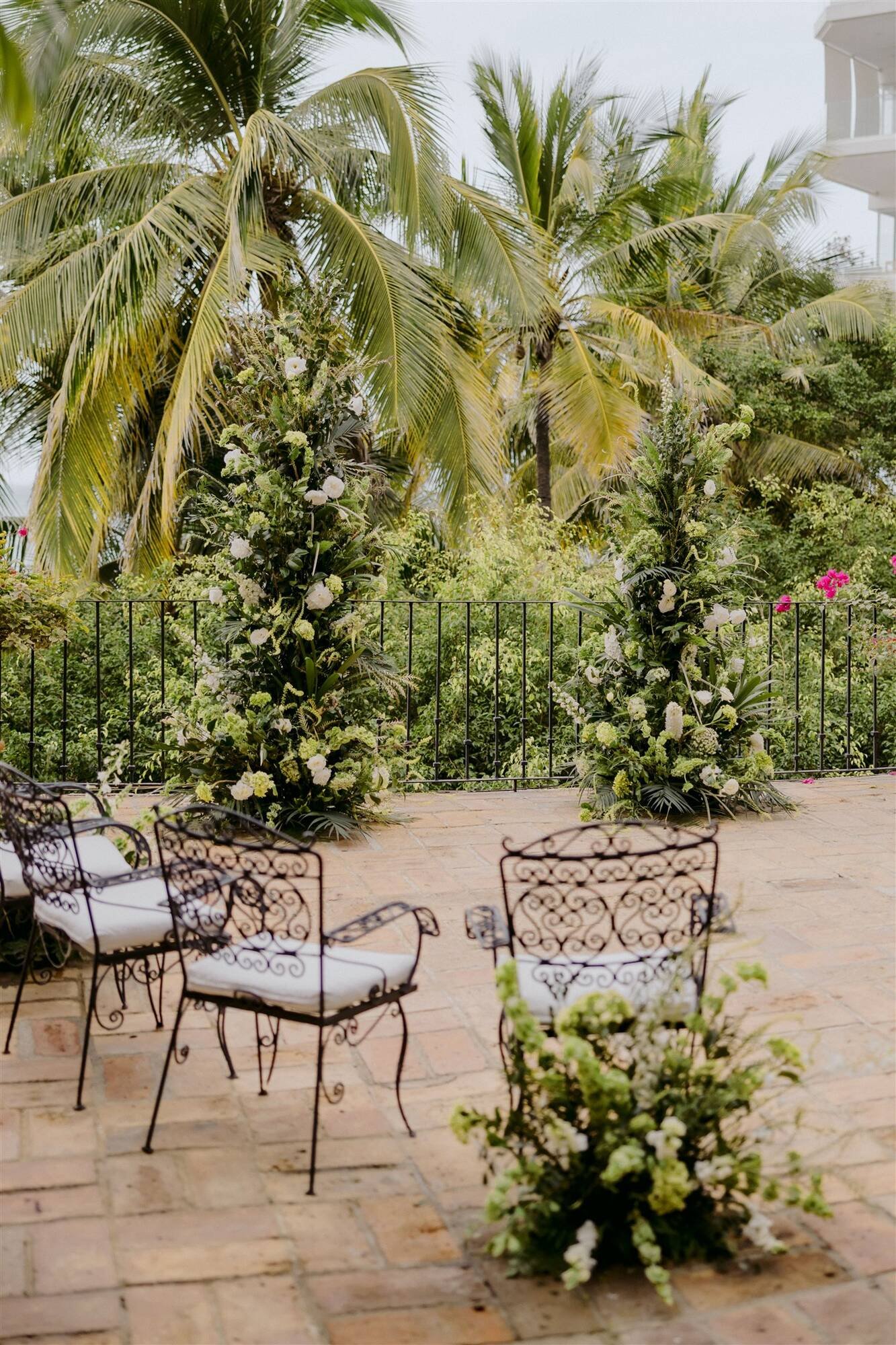 Asymmetric white and green floral columns by Flowers by JJ at Quinta de Los Leones