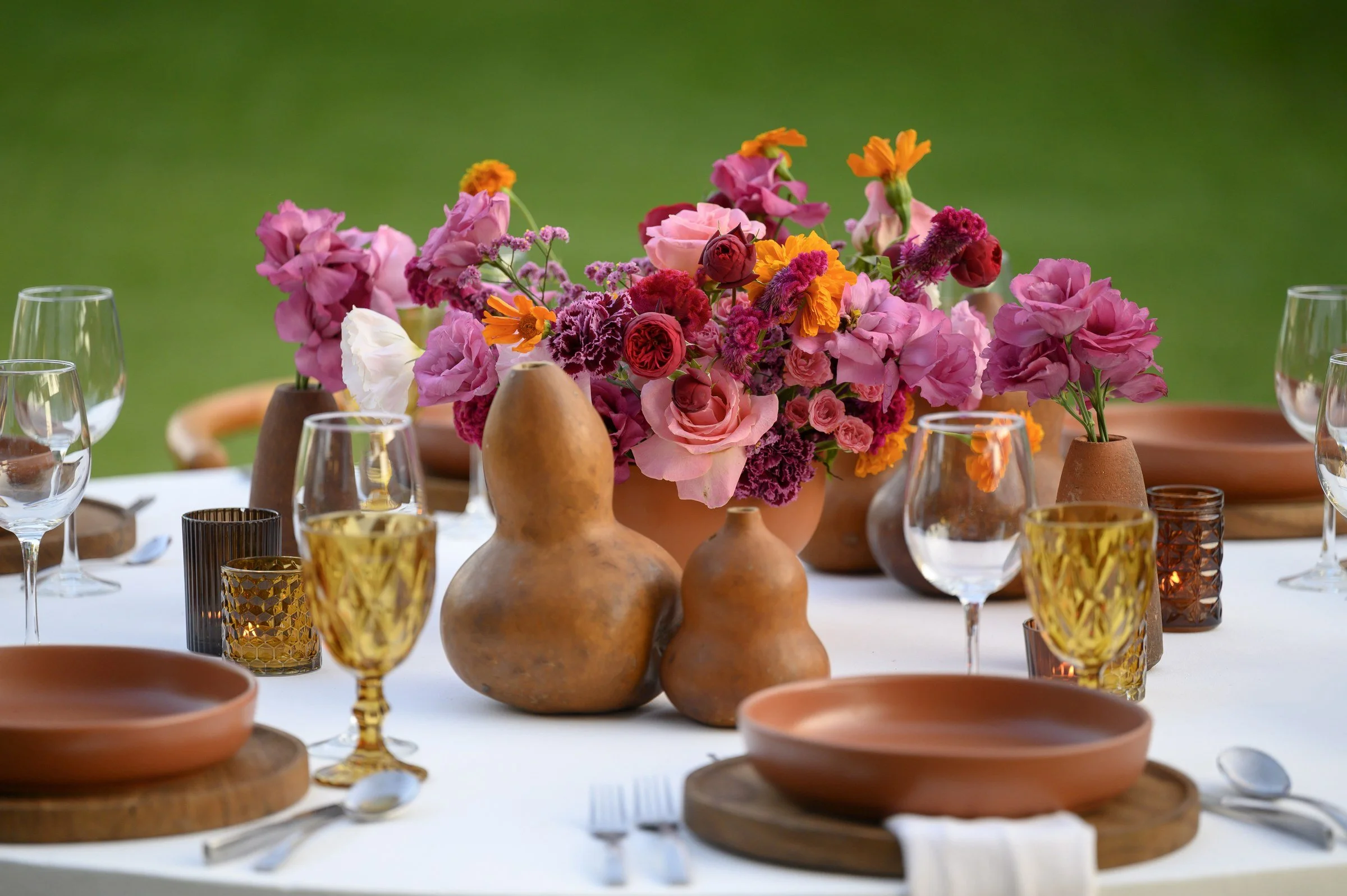"Bules" clustered beside a magenta centerpiece on a white round table