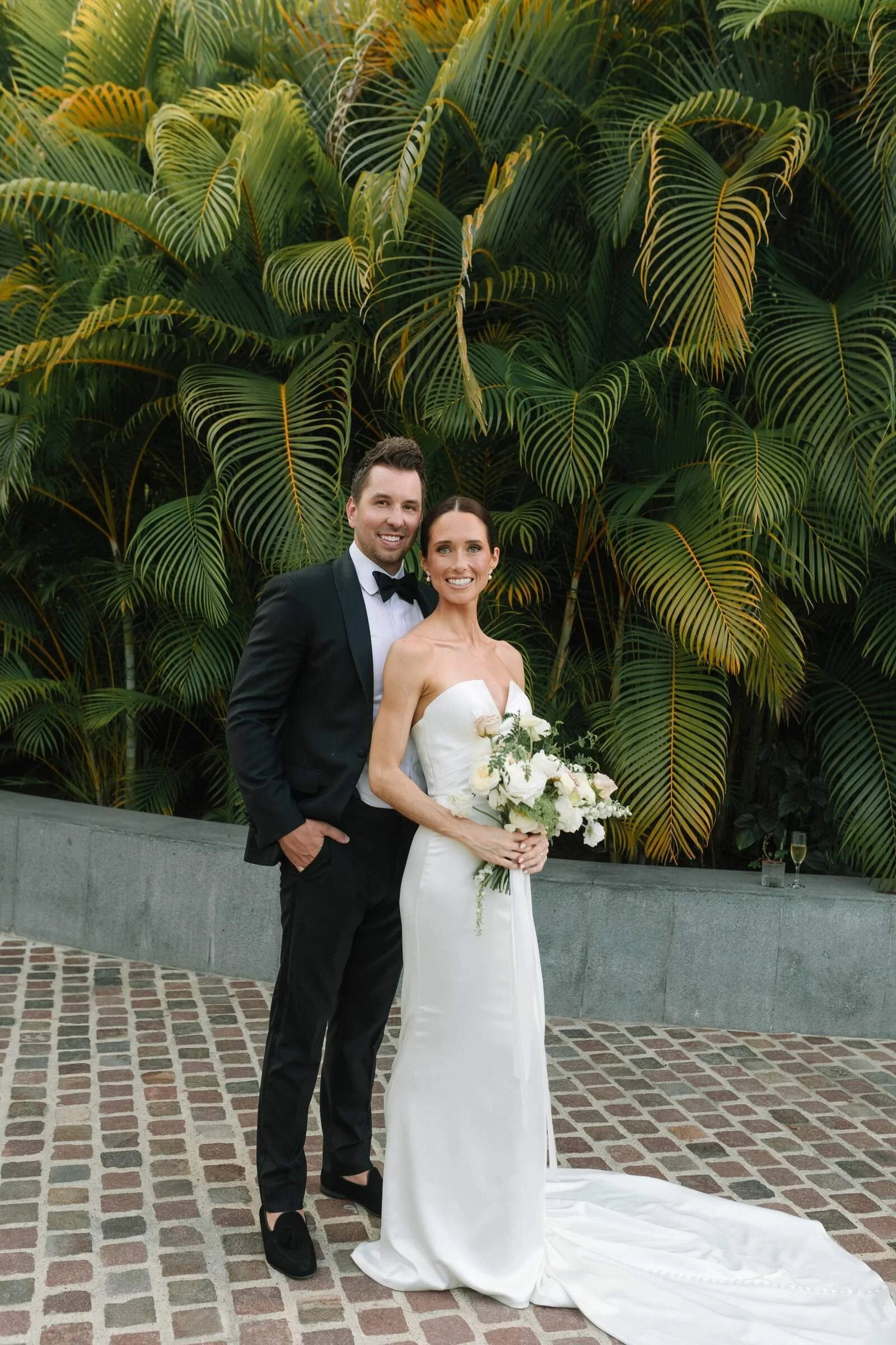 Bride holding her white garden bouquet beside the groom at Garza Blanca, Puerto Vallarta