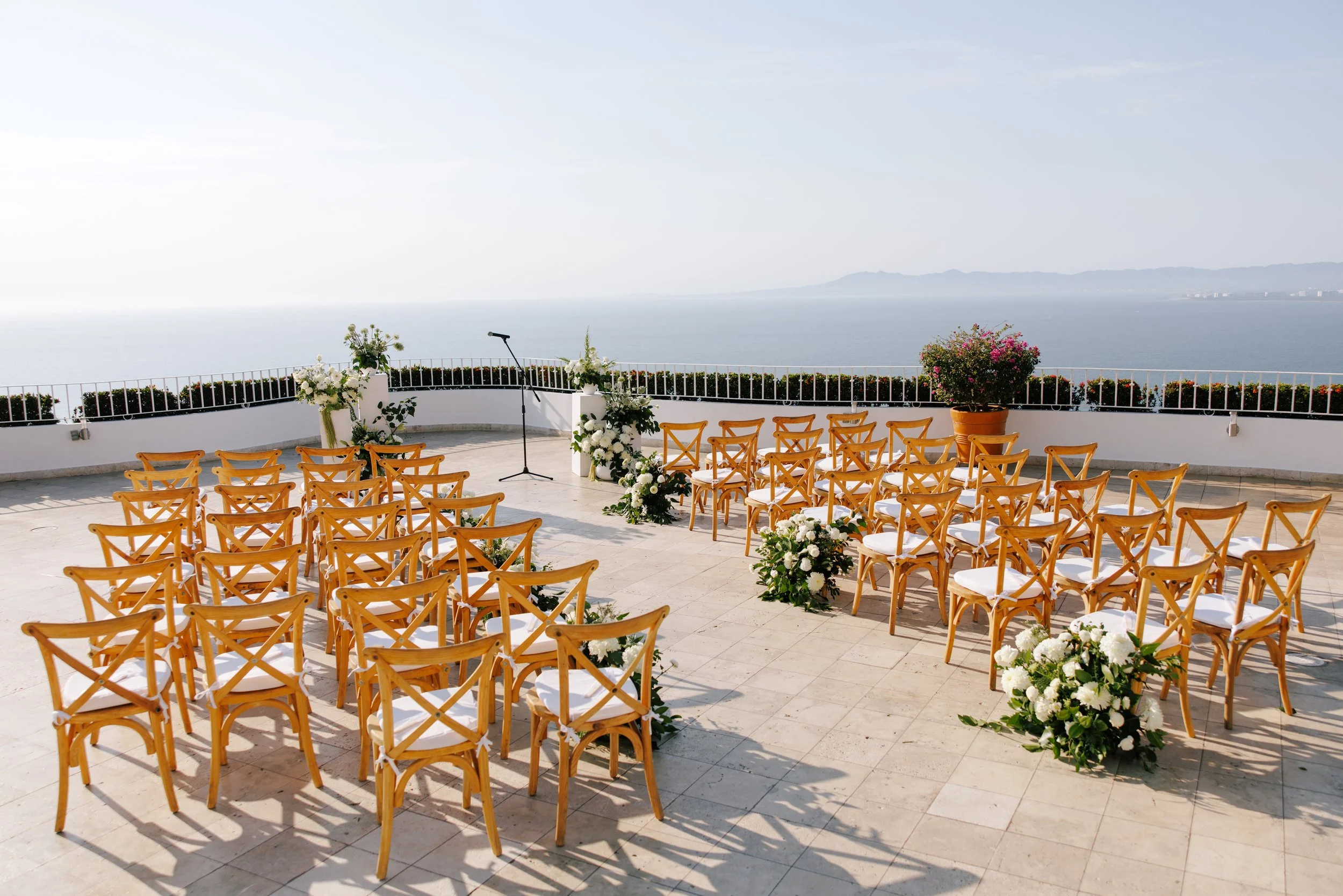 Ceremony chairs and white aisle florals facing Banderas Bay at Grand Miramar