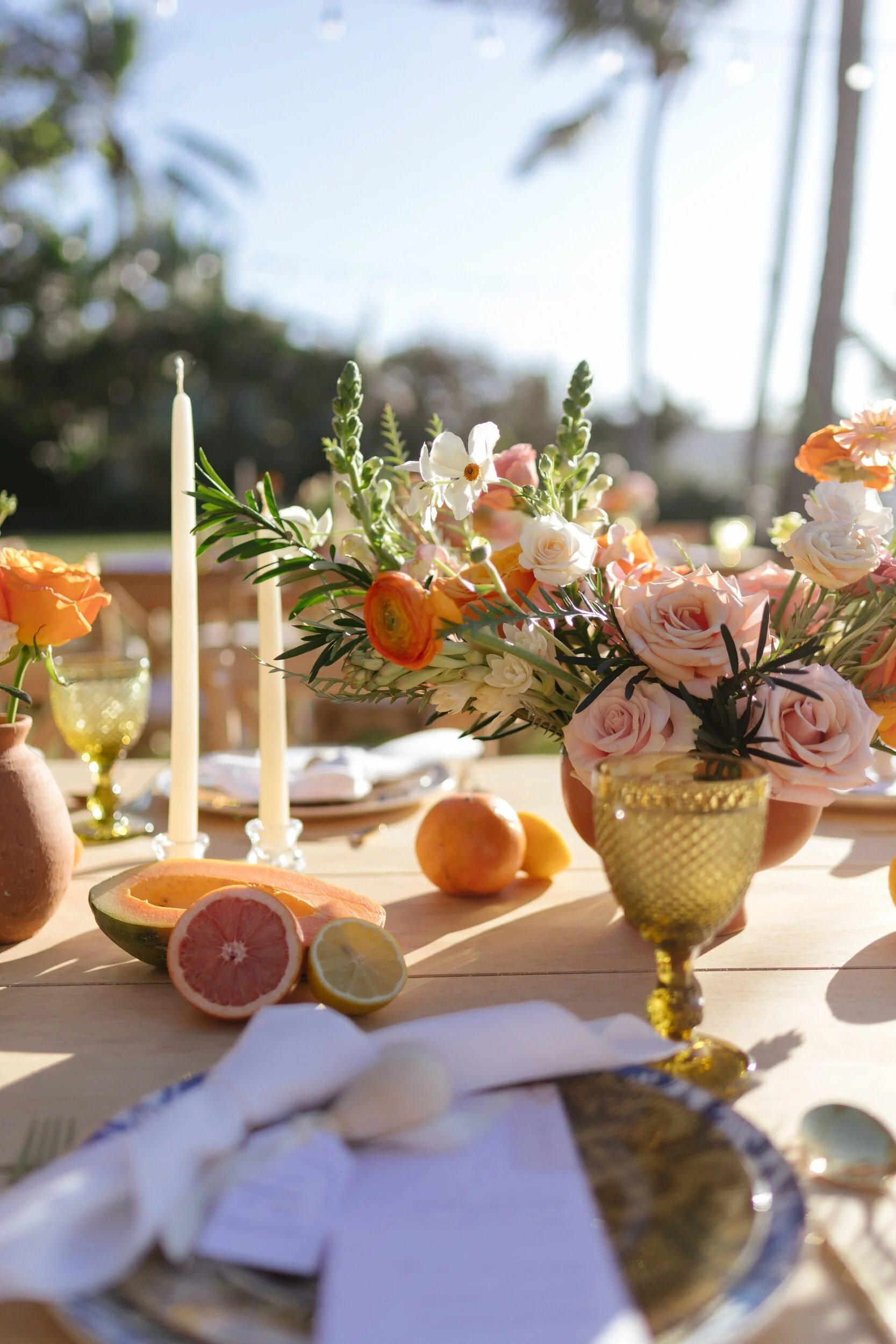 Welcome party table with citrus, peach roses and taper candles