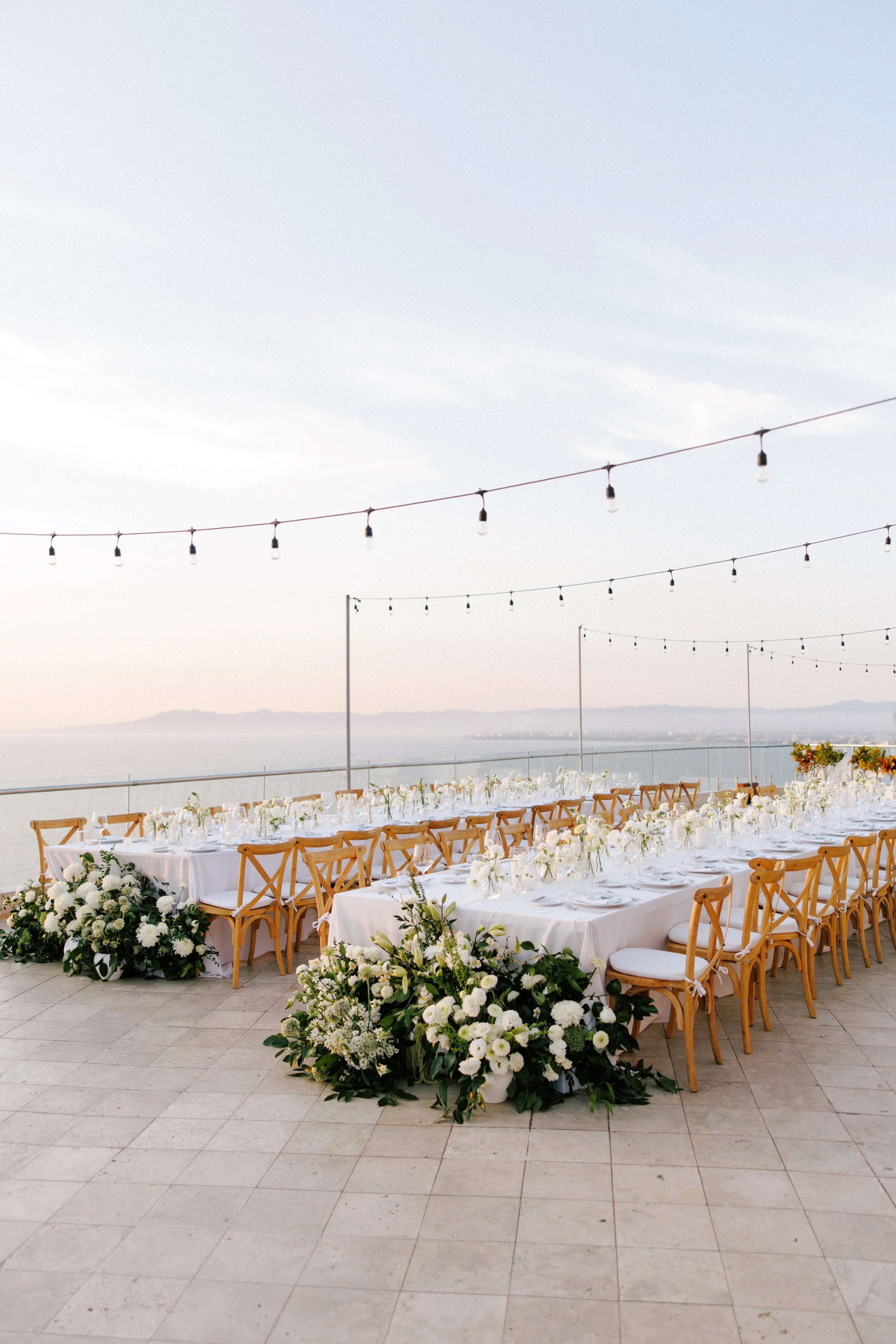 Reception tables under string lights above Banderas Bay at Grand Miramar