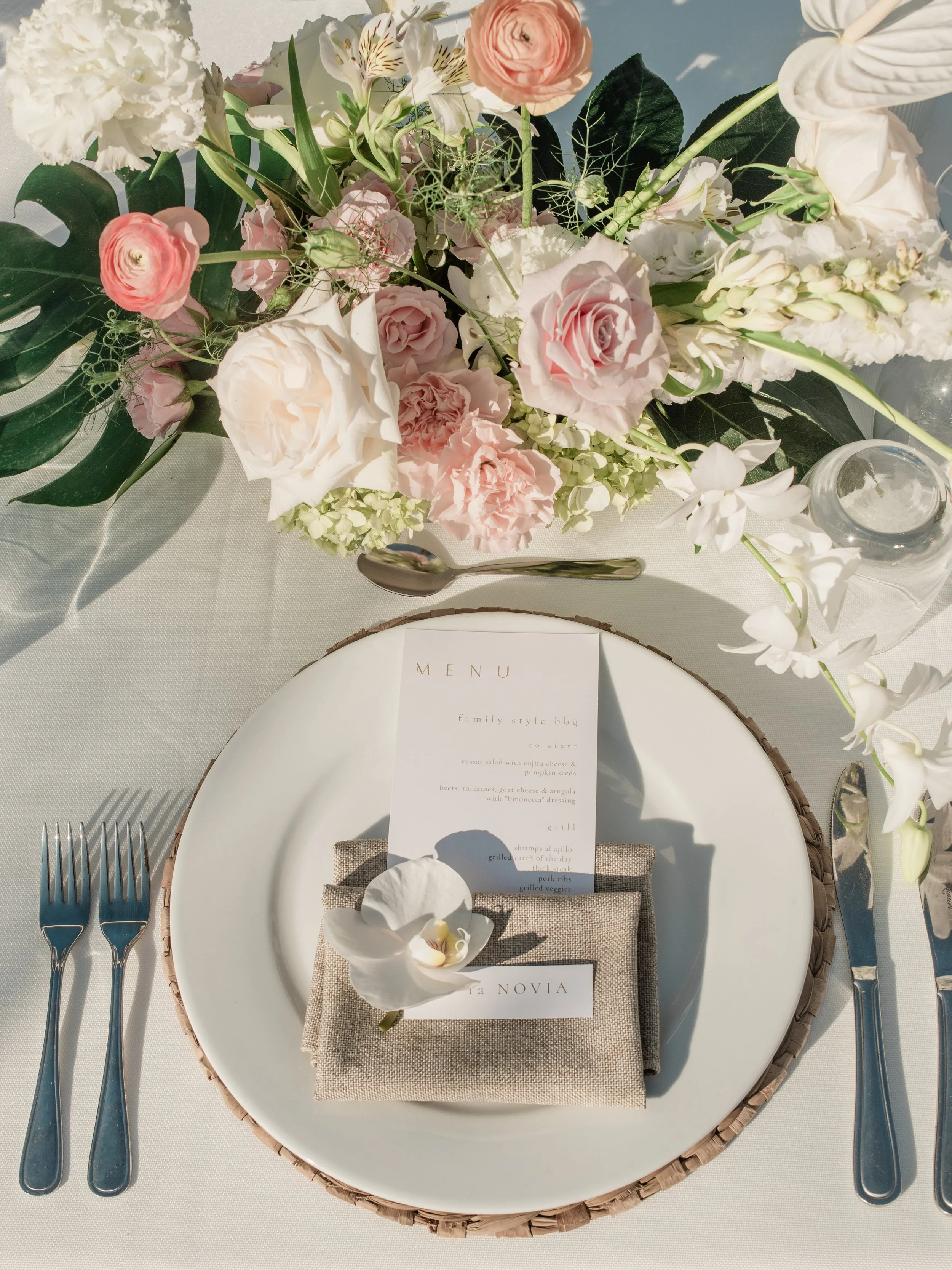 Place setting with menu and a white phalaenopsis orchid at W Punta de Mita