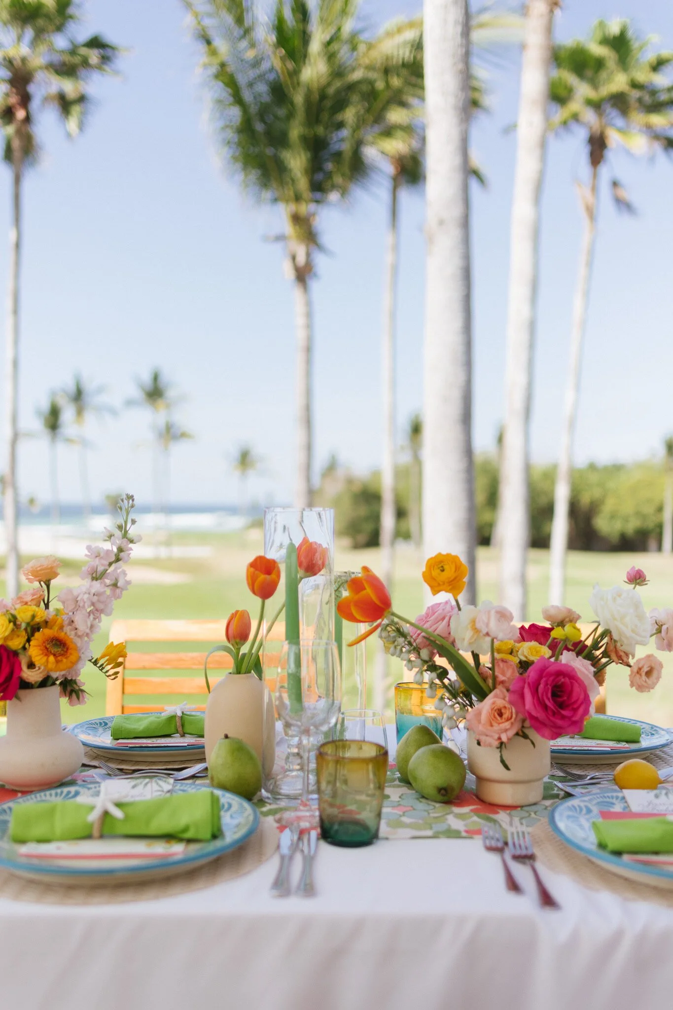 Welcome party table with citrus florals under palms at Four Seasons Punta Mita