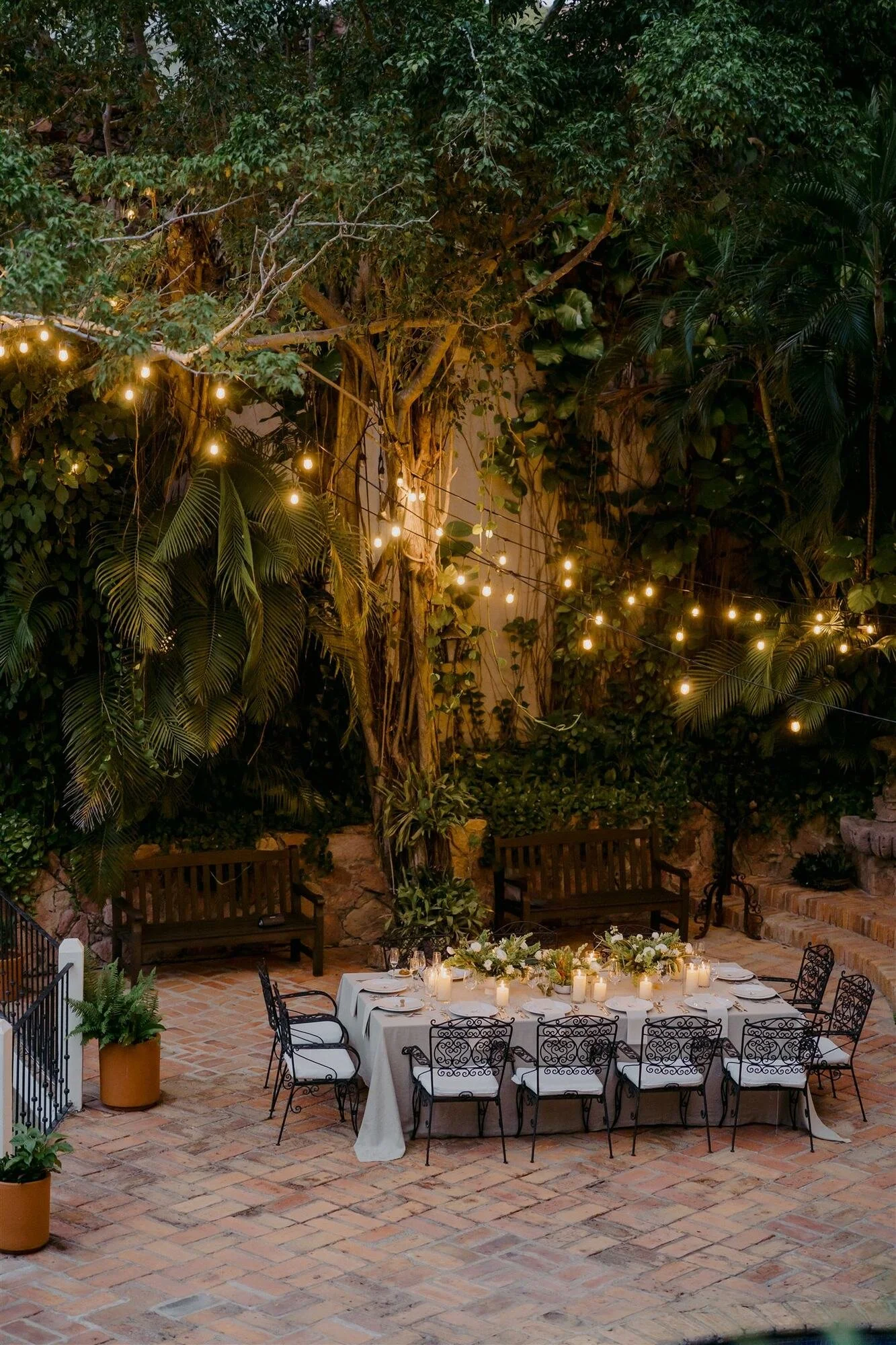 Candlelit wedding dinner under string lights in the courtyard at Quinta de Los Leones