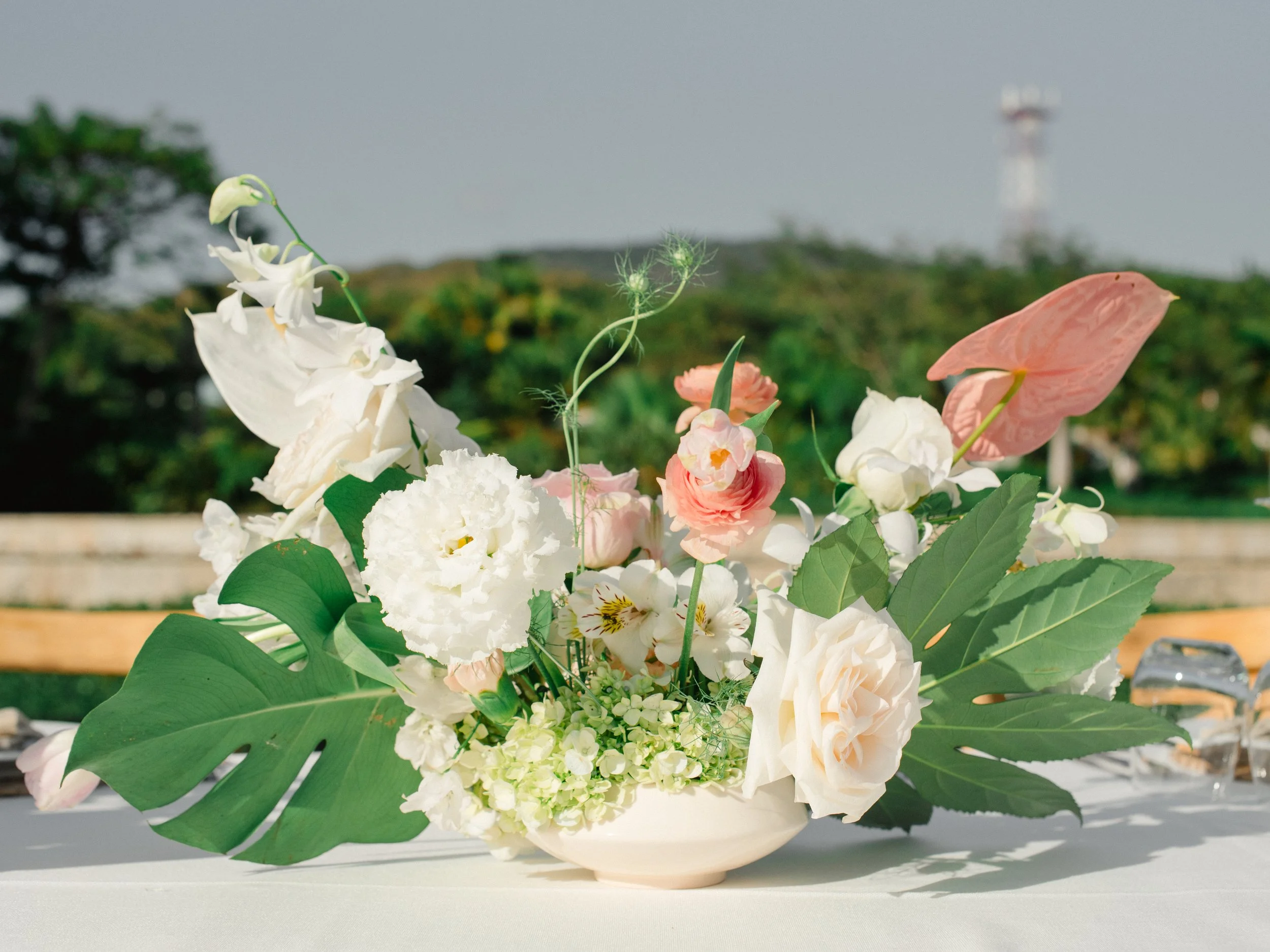 Blush centerpiece with pink anthurium, roses and monstera at W Punta de Mita
