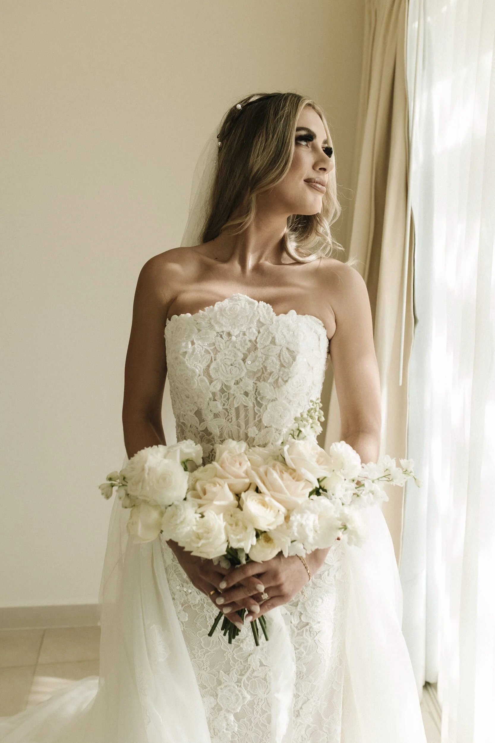 Bride holding a white garden rose bouquet at Grand Velas Riviera Nayarit