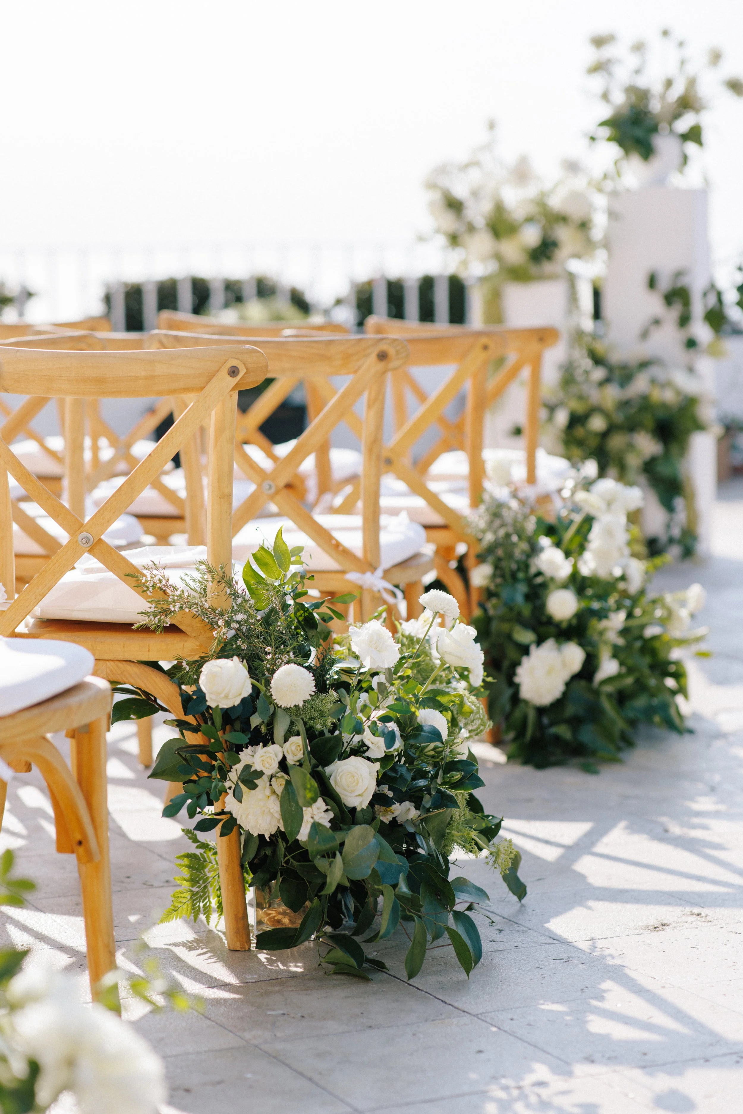 Grounded white arrangement beside the ceremony chairs at Grand Miramar, Puerto Vallarta
