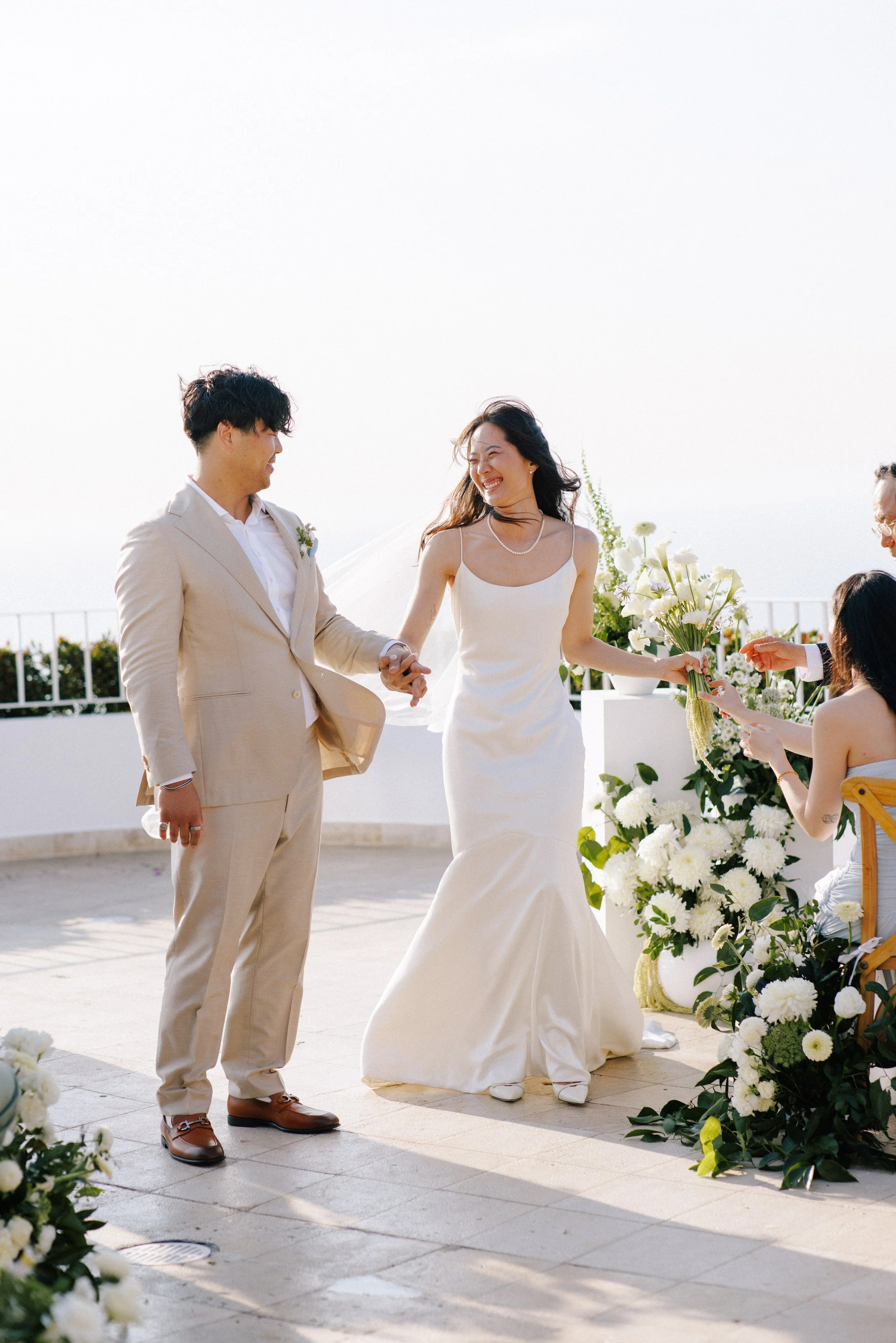 Couple walking back down the aisle past white florals at Grand Miramar