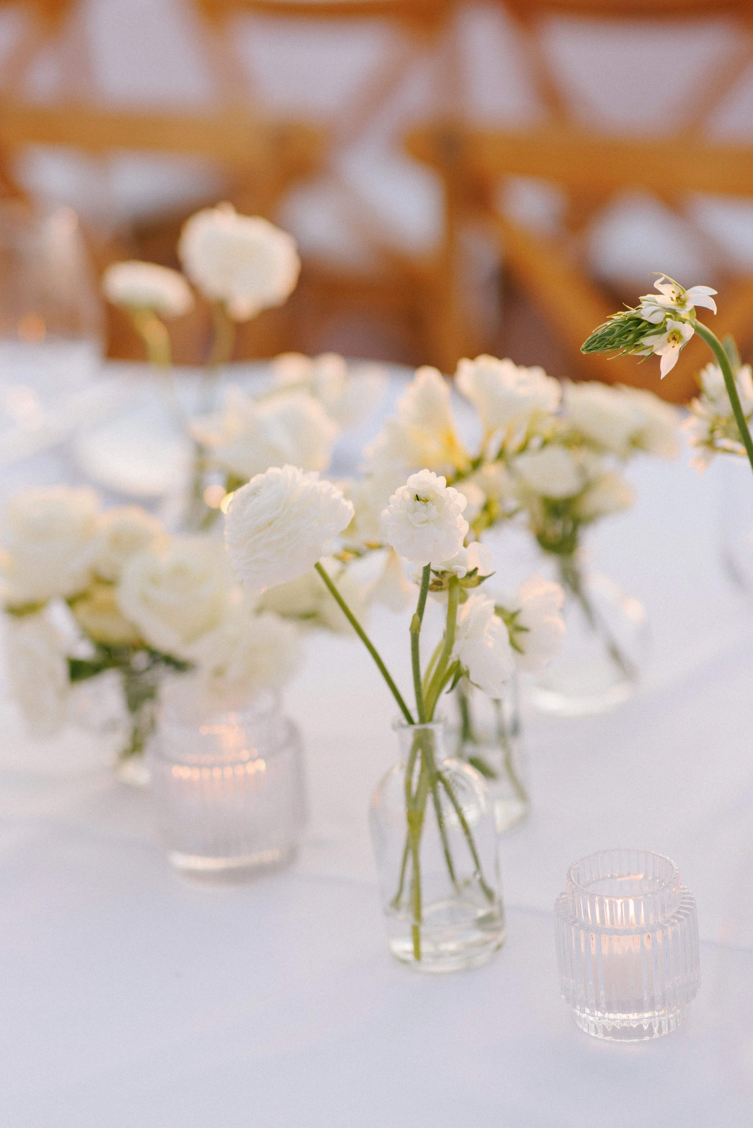 White bud vases and candles along the reception table at Grand Miramar