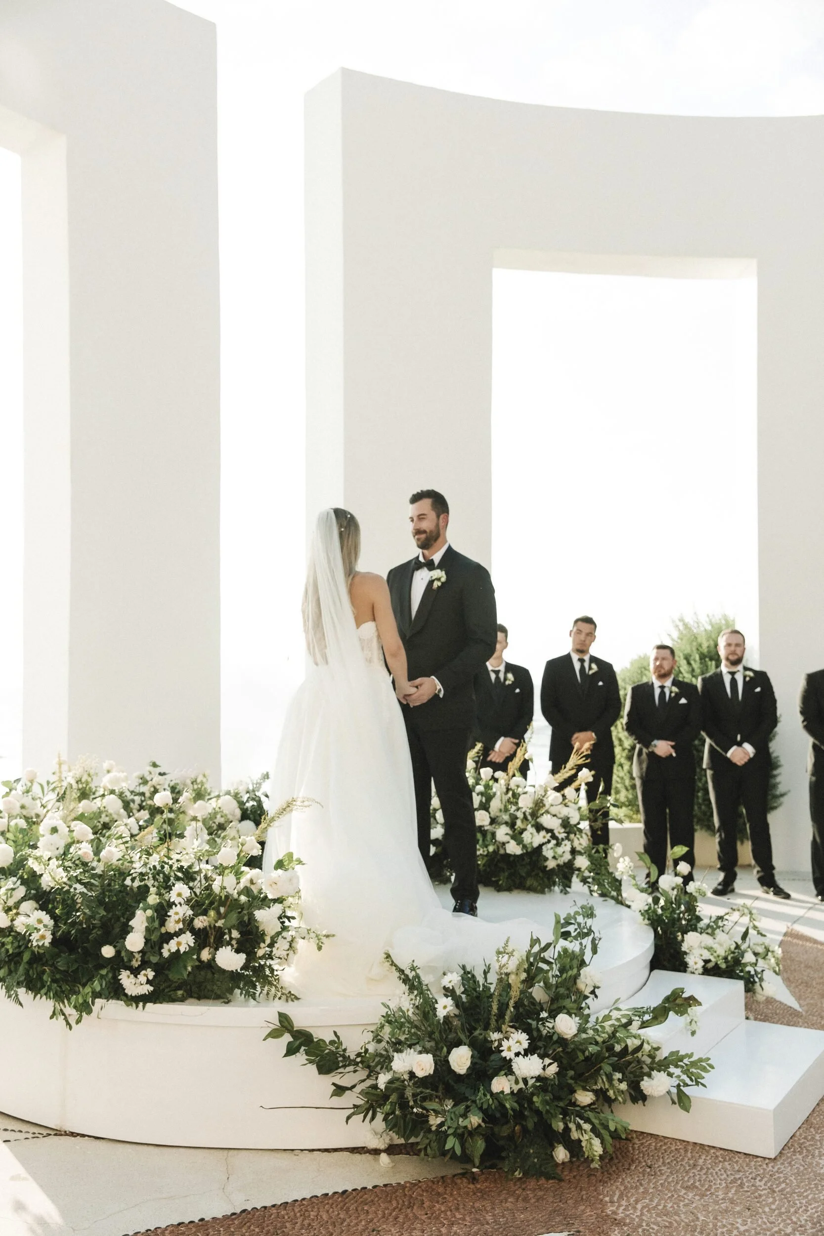 Couple at the altar framed by white florals at Grand Velas Riviera Nayarit