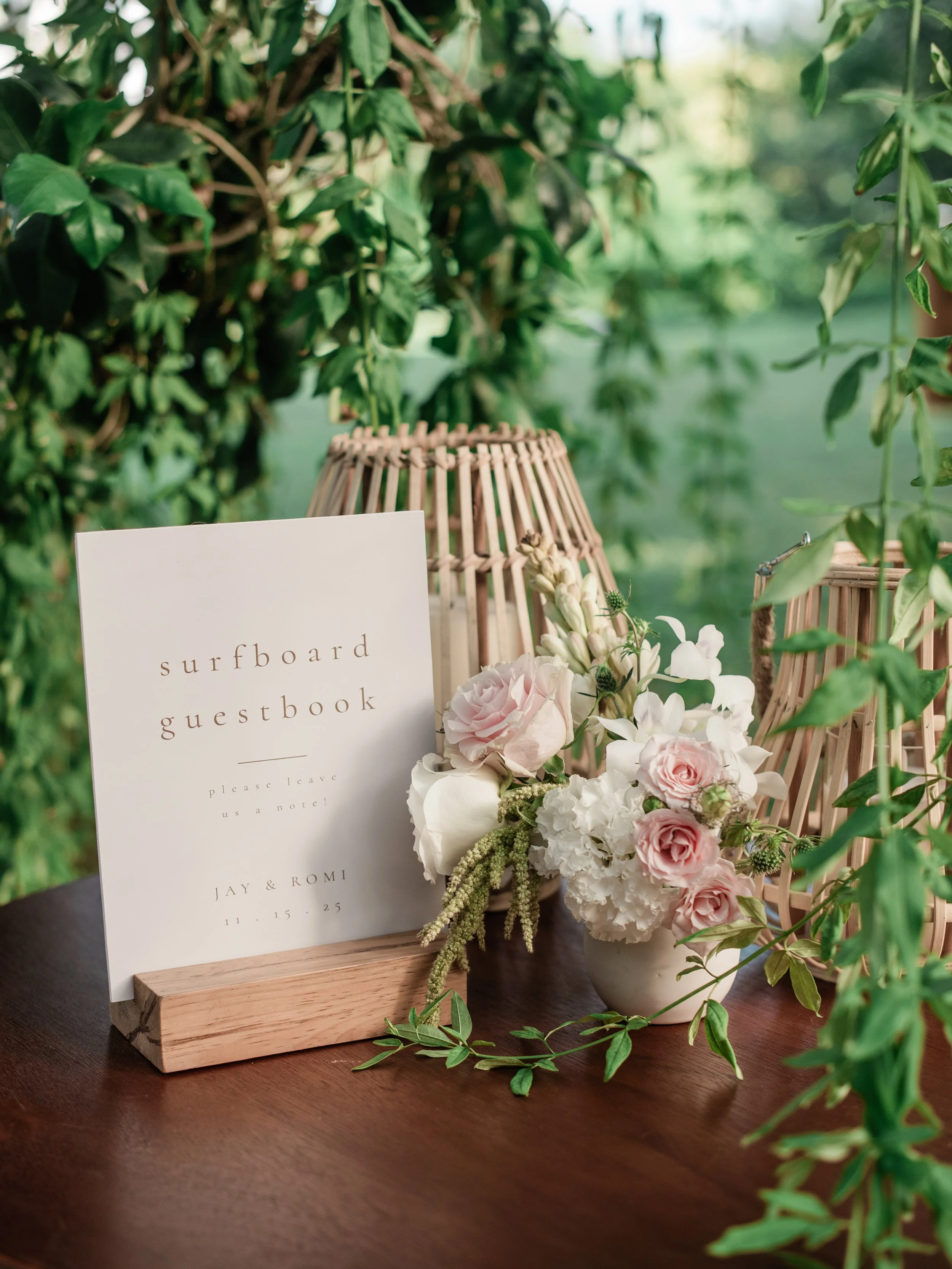 Blush rose and orchid arrangement beside the surfboard guestbook sign at W Punta de Mita