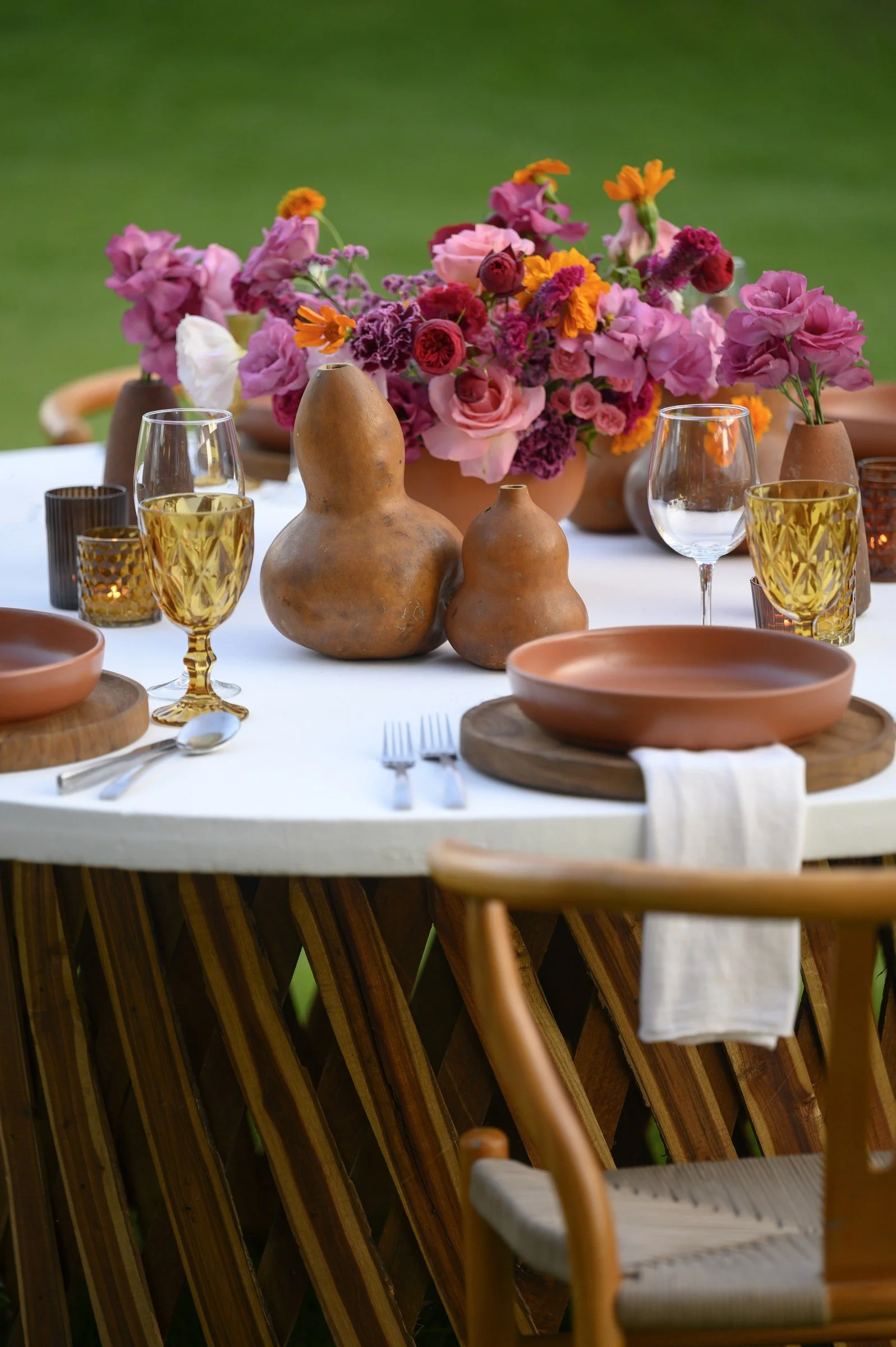 Detail of "bules" and amber glassware beside a fuchsia centerpiece