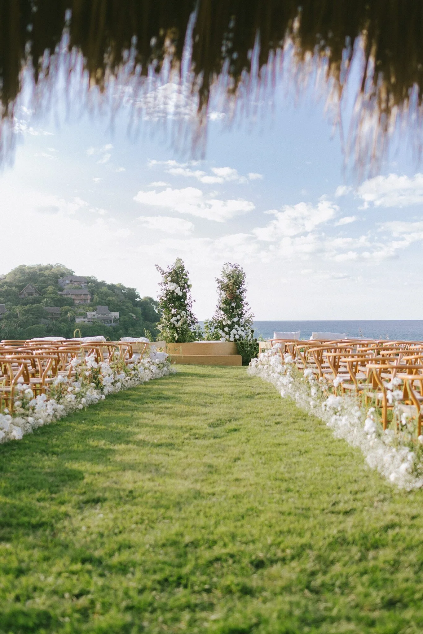 Ceremony aisle framed by topiaries above the ocean in Sayulita