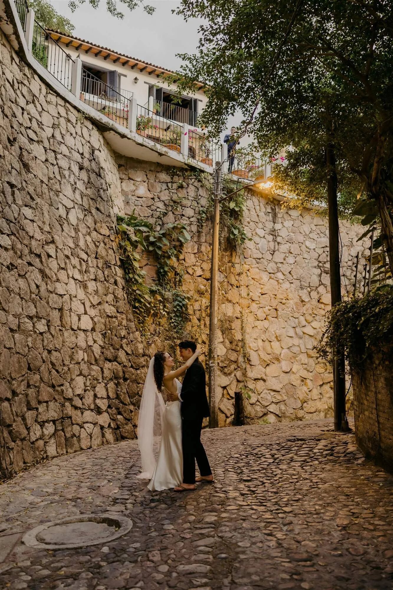 Bride and groom on a cobblestone lane in Puerto Vallarta below Quinta de Los Leones