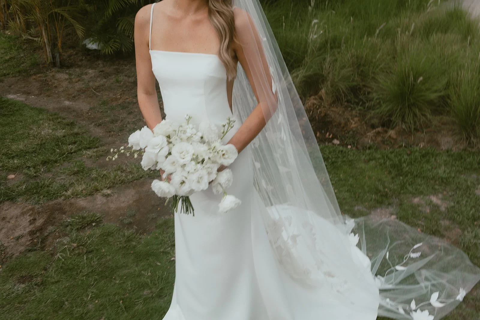 Bride holding a white bridal bouquet with her veil at a Punta Mita
wedding