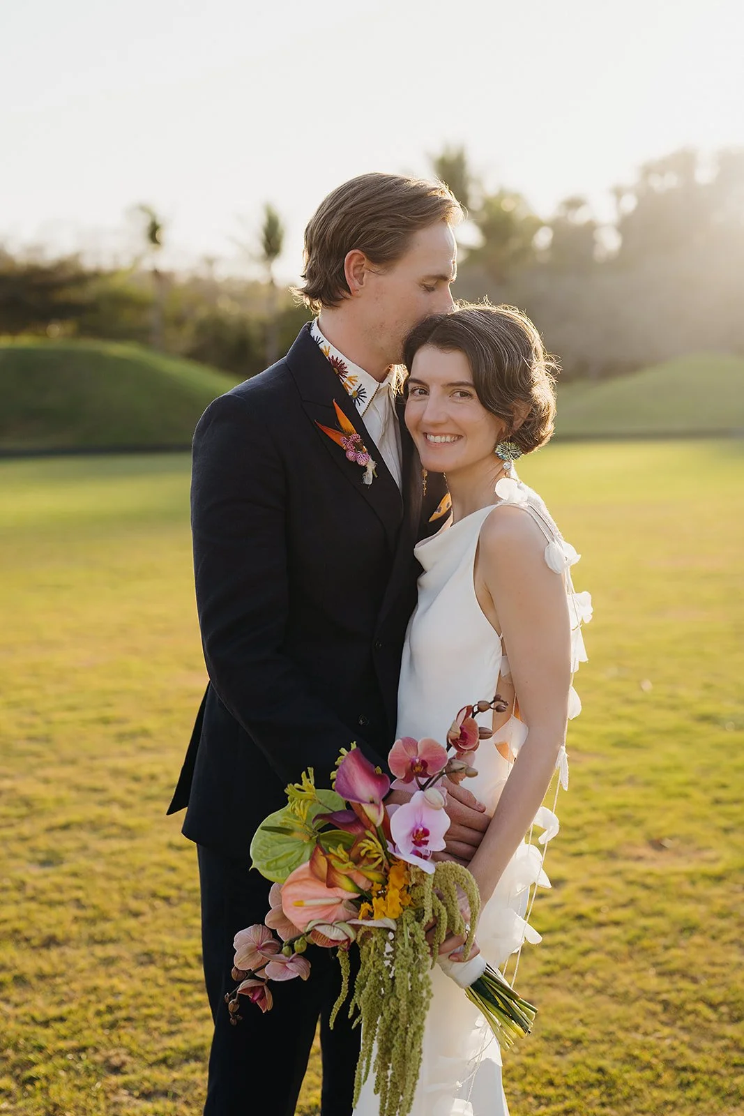 Bride with a bouquet of orchid, anthurium and trailing amaranthus at Tierra Tropical Polo Club