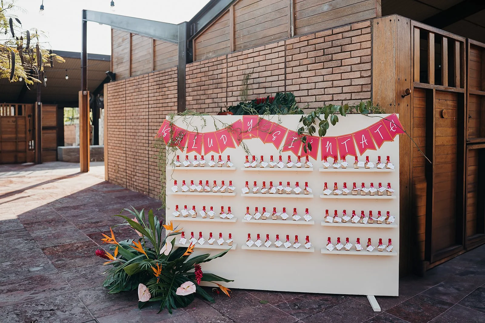 Escort card wall with a tropical base in coral and green at Tierra Tropical Polo Club