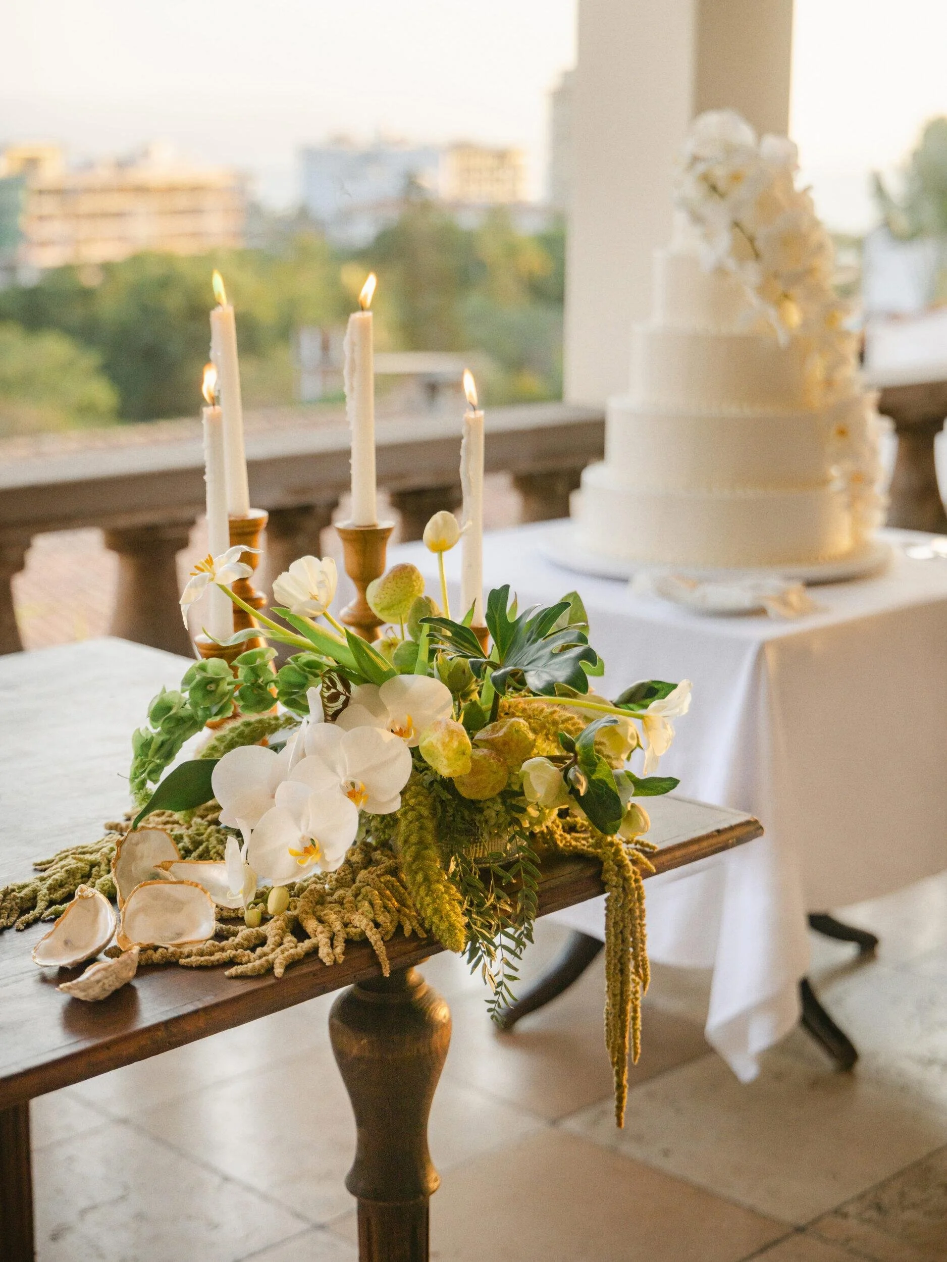 Cake table with white orchids and taper candles at Casa Kimberly