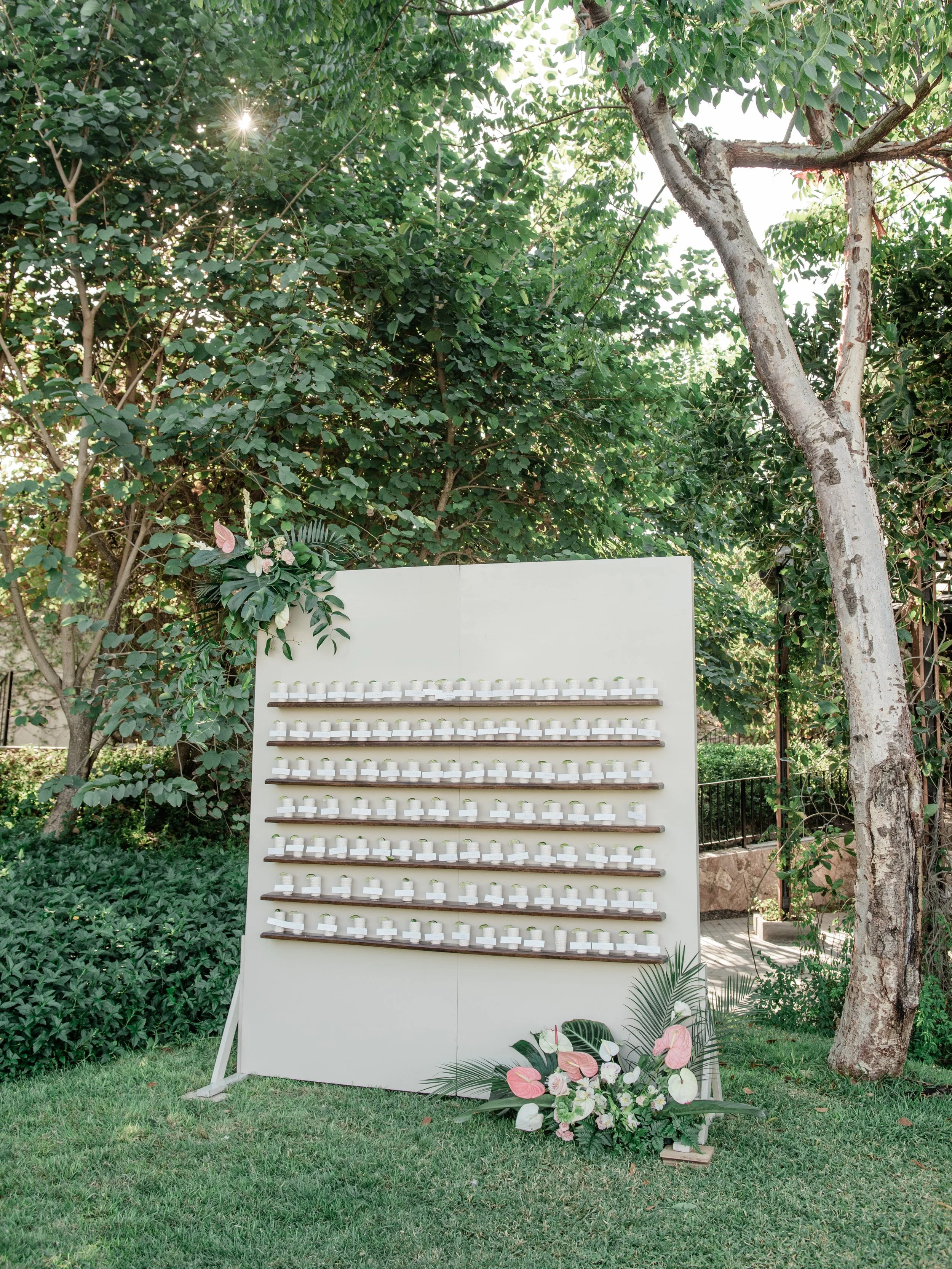 Escort card wall with pink anthurium and monstera at W Punta de Mita